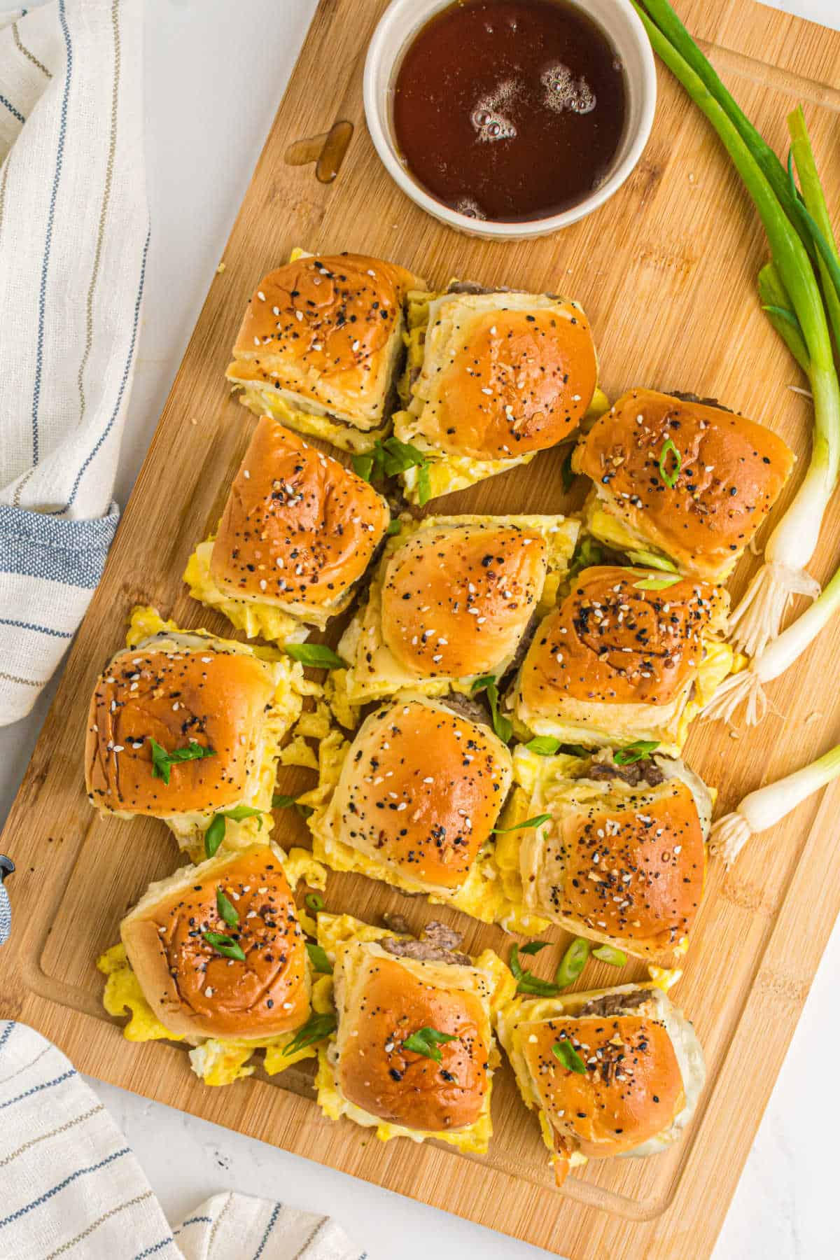 Breakfast sliders on a wooden cutting board.