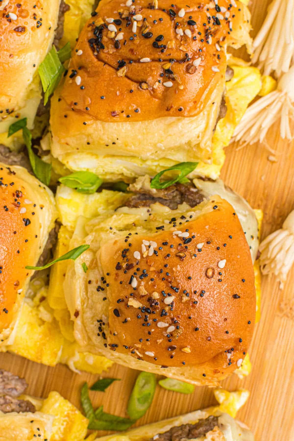 Breakfast sliders on a wooden cutting board.