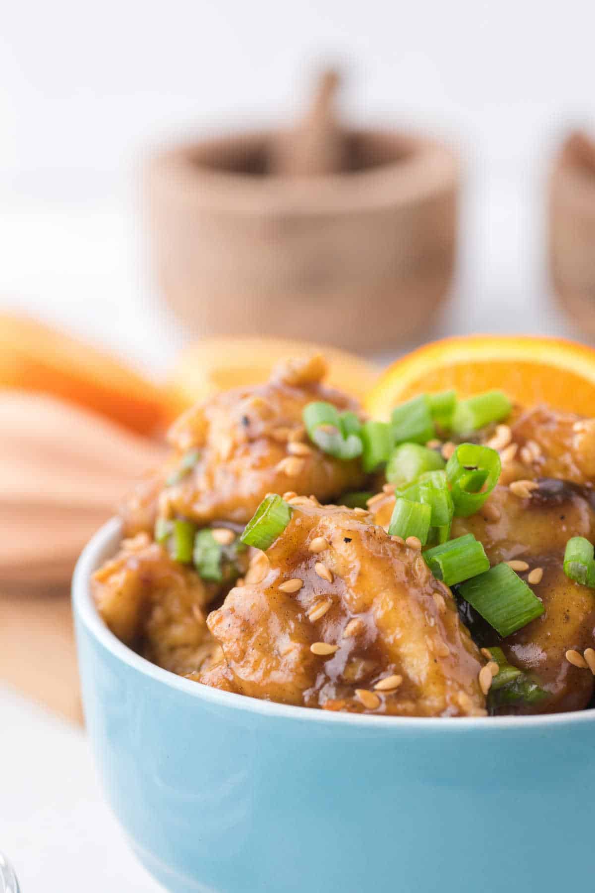 Orange chicken in a blue bowl.