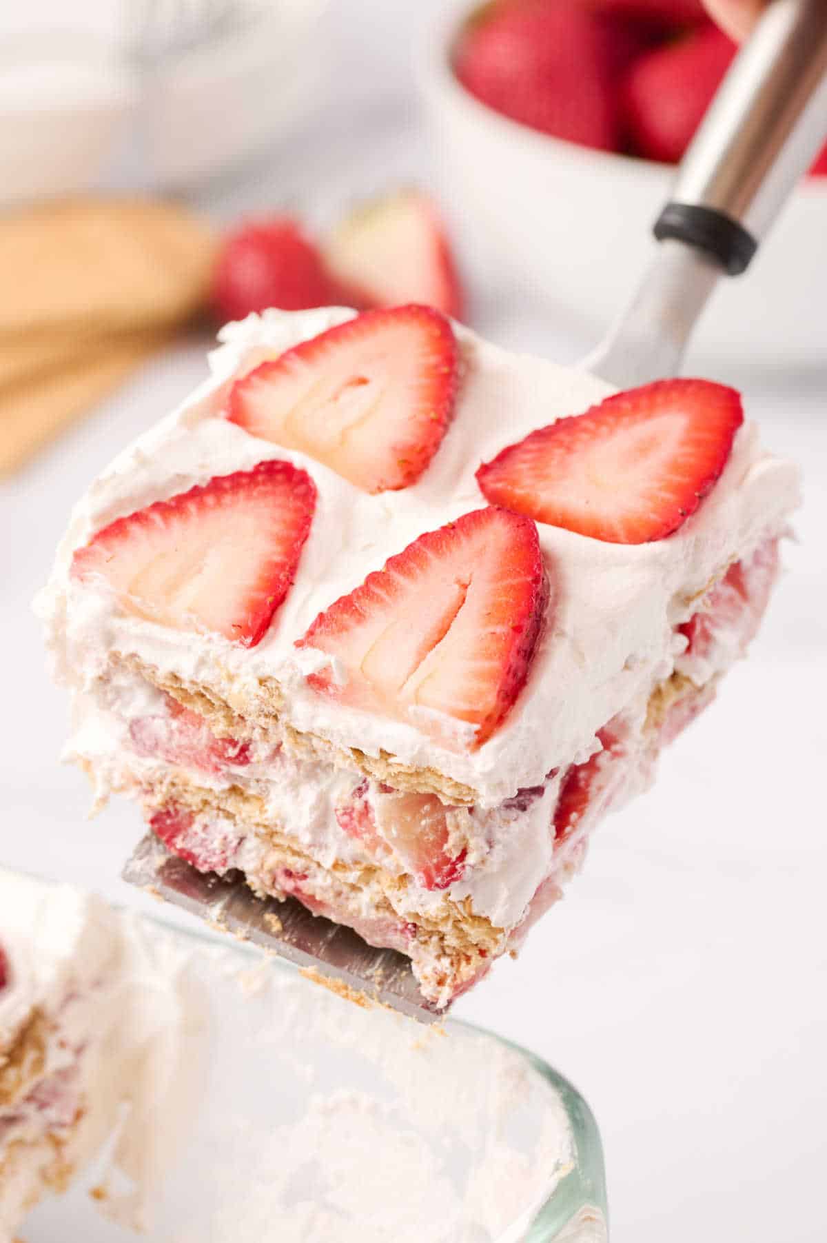 A serving spatula with a slice of strawberry icebox cake.