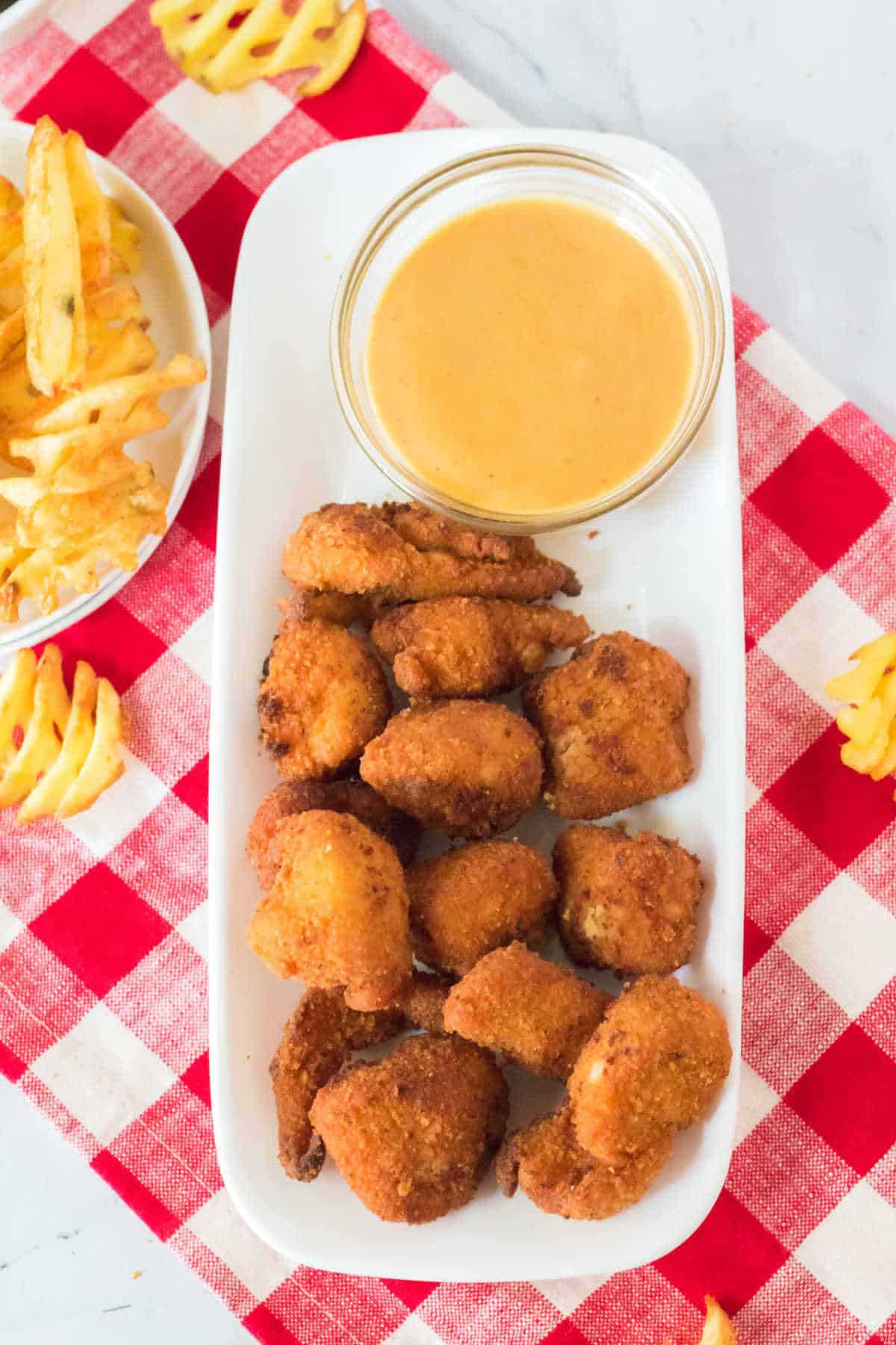 Copycat Chick Fil A Nuggets on a platter with dipping sauce.