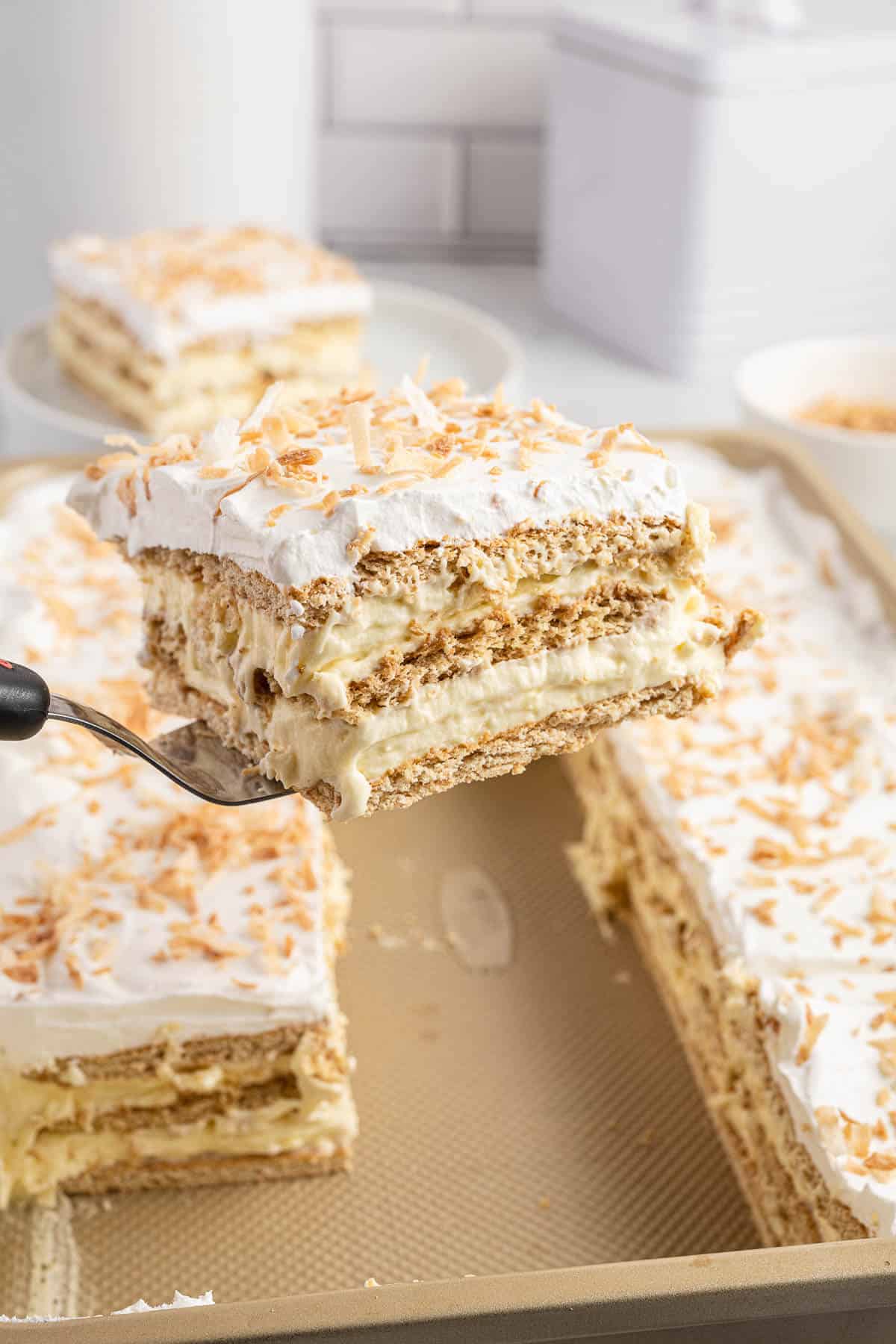 A serving spatula with a slice of coconut icebox cake.