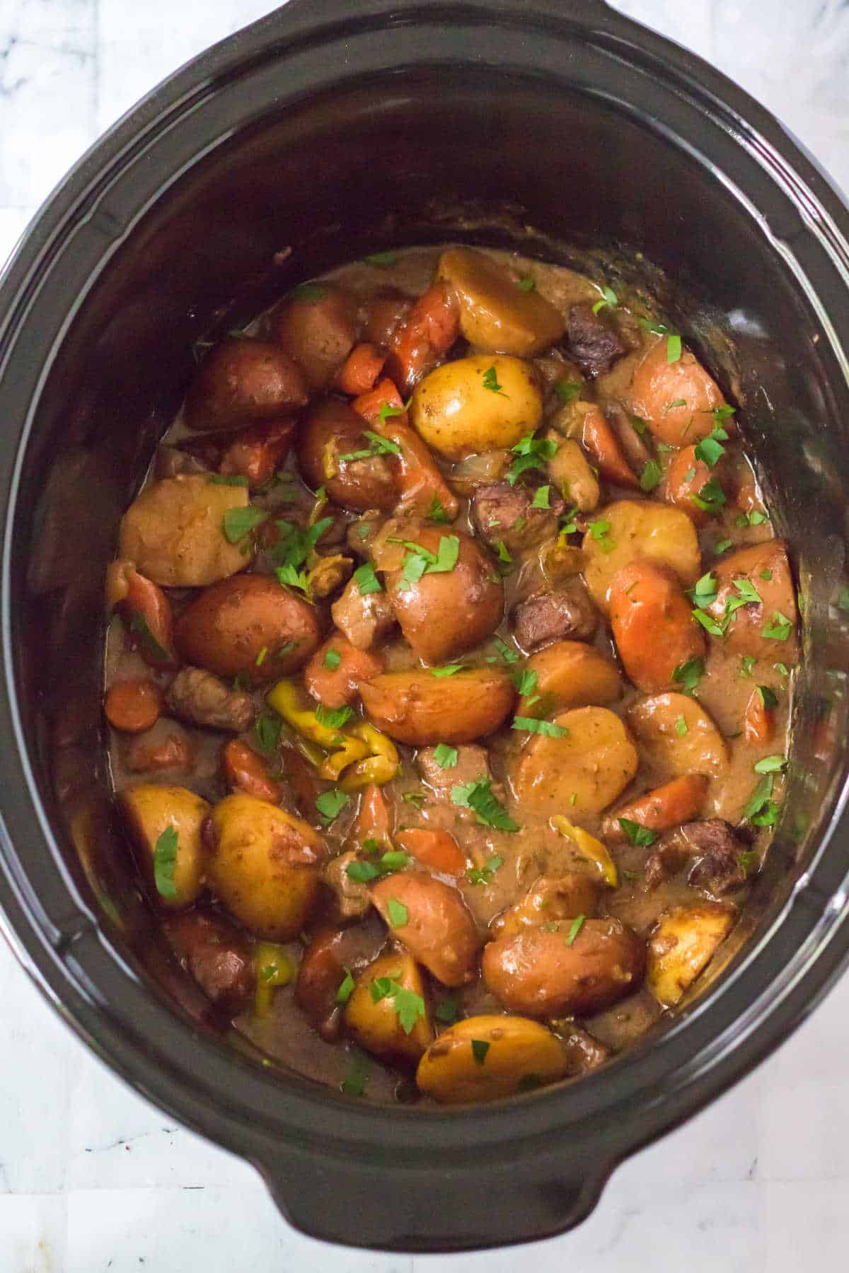 A black crockpot with Mississippi beef stew.