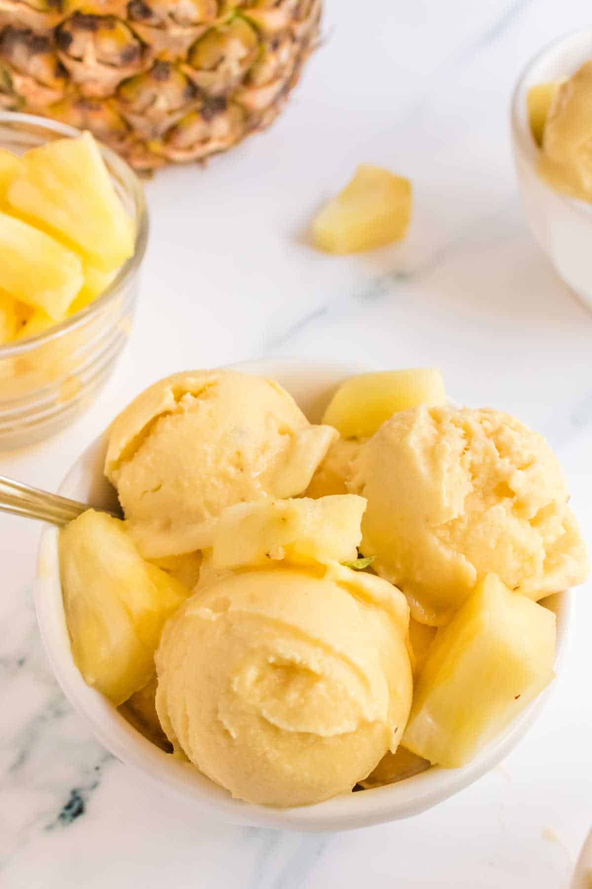 Pineapple Ice Cream in a bowl with a spoon.