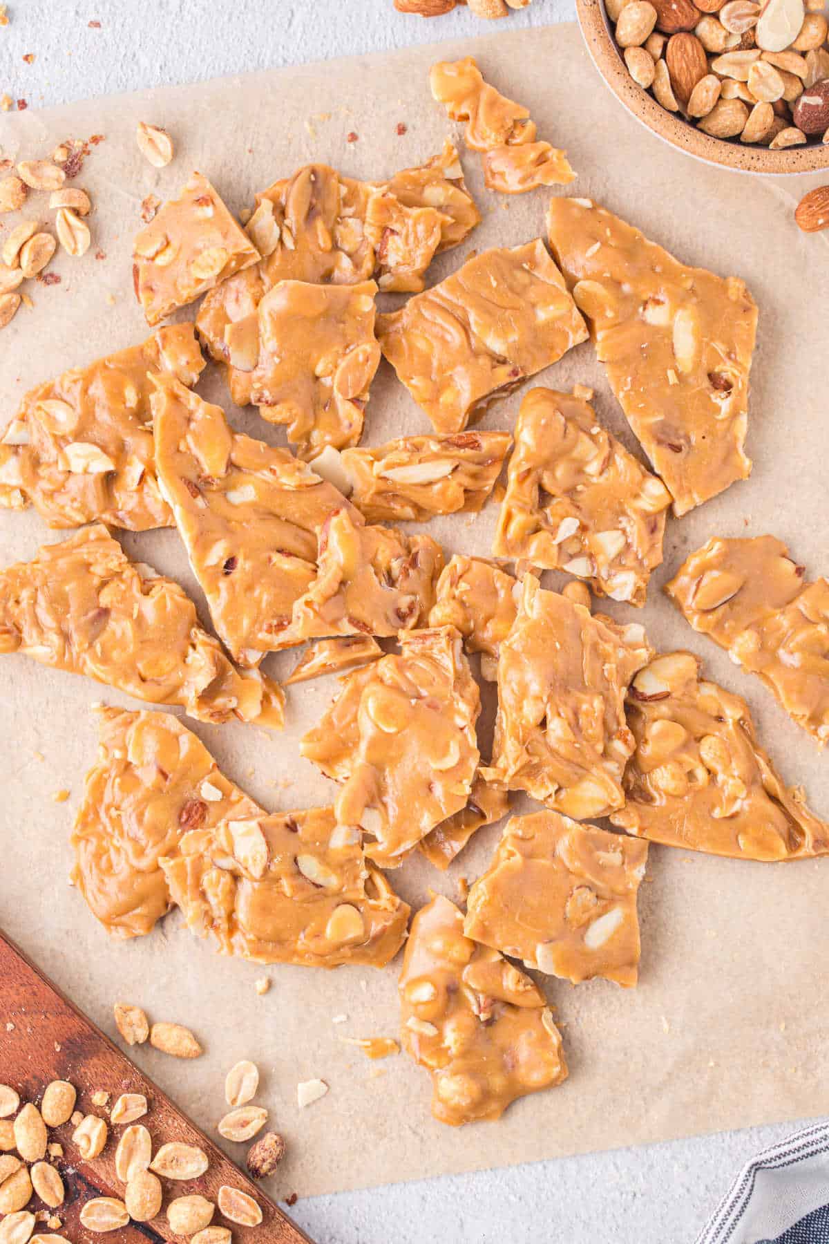 Caramel nut brittle on a piece of brown parchment paper.