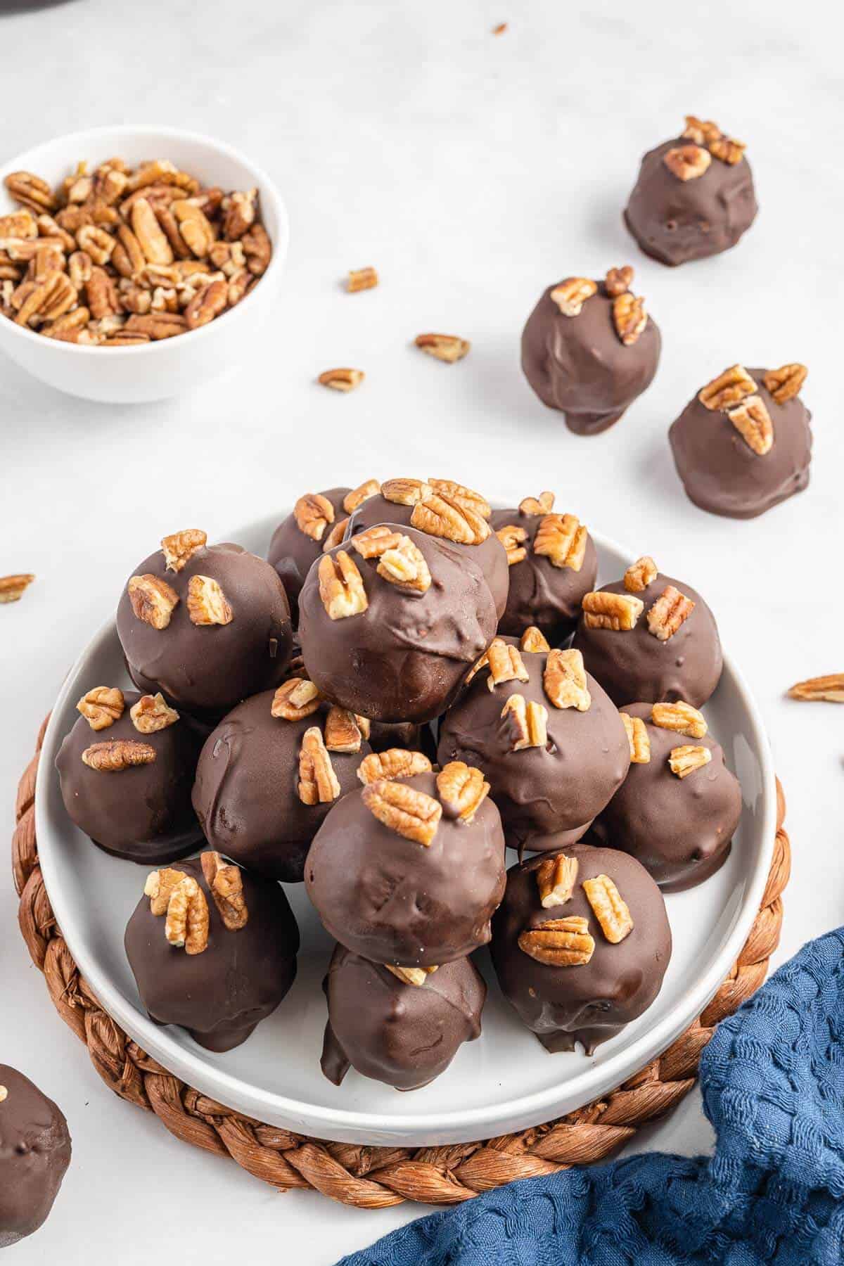 Pecan pie balls piled on to a white plate.