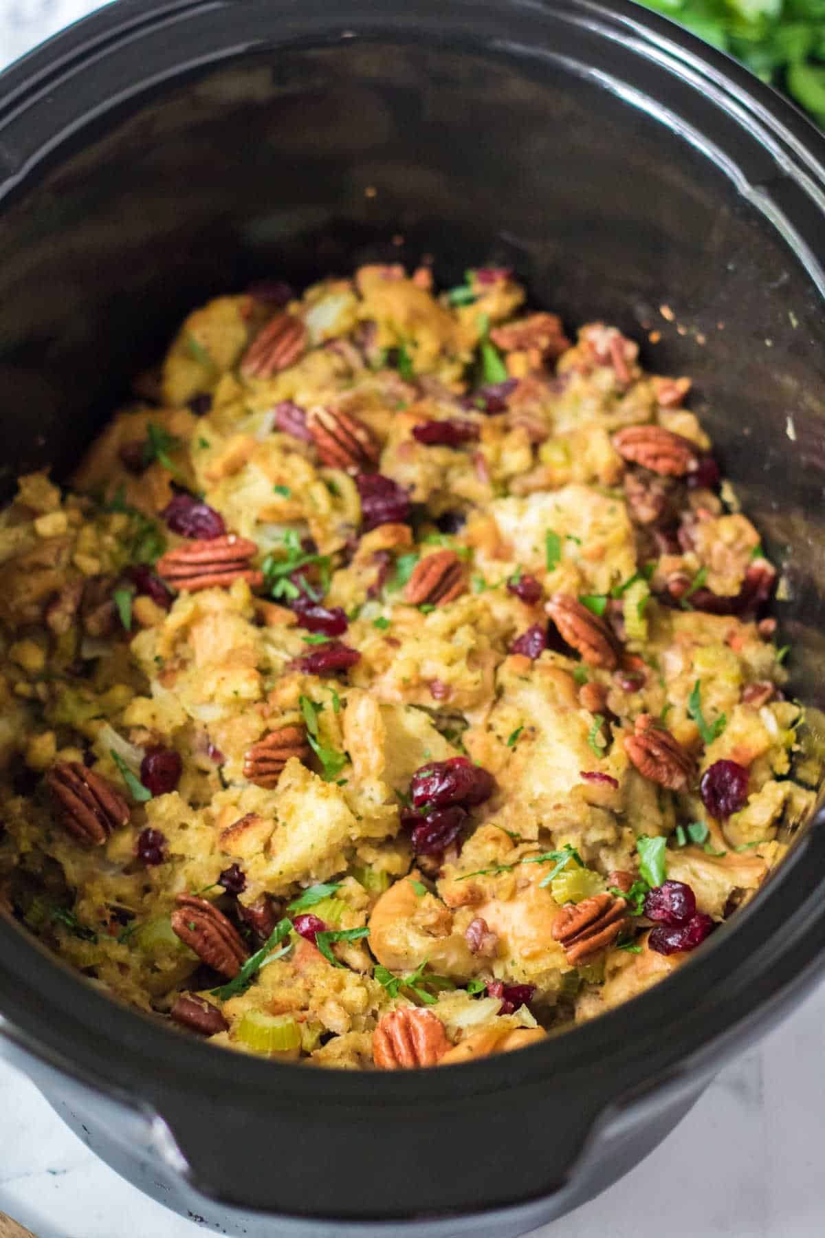Cranberry pecan stuffing in a black crockpot.