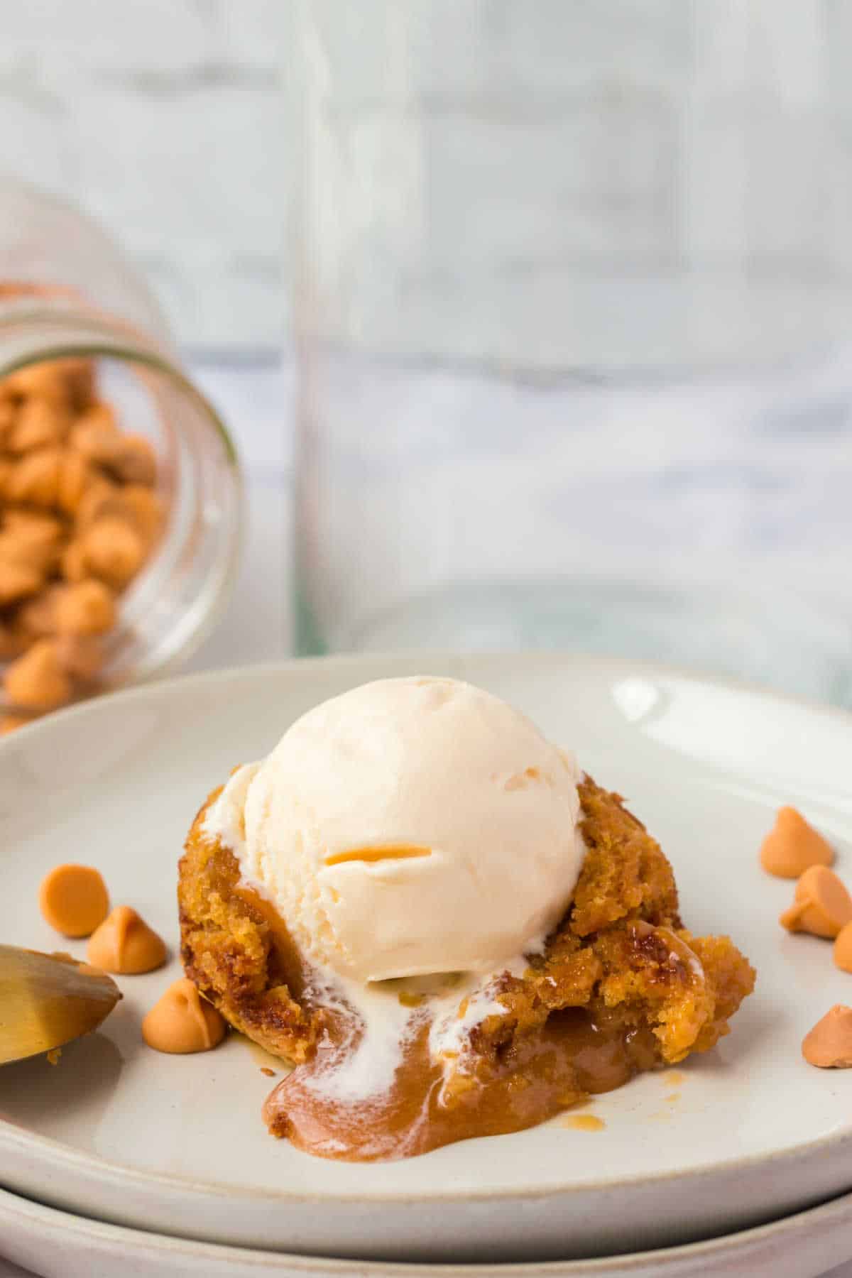 A butterscotch lava cake cut open and topped with vanilla ice cream.