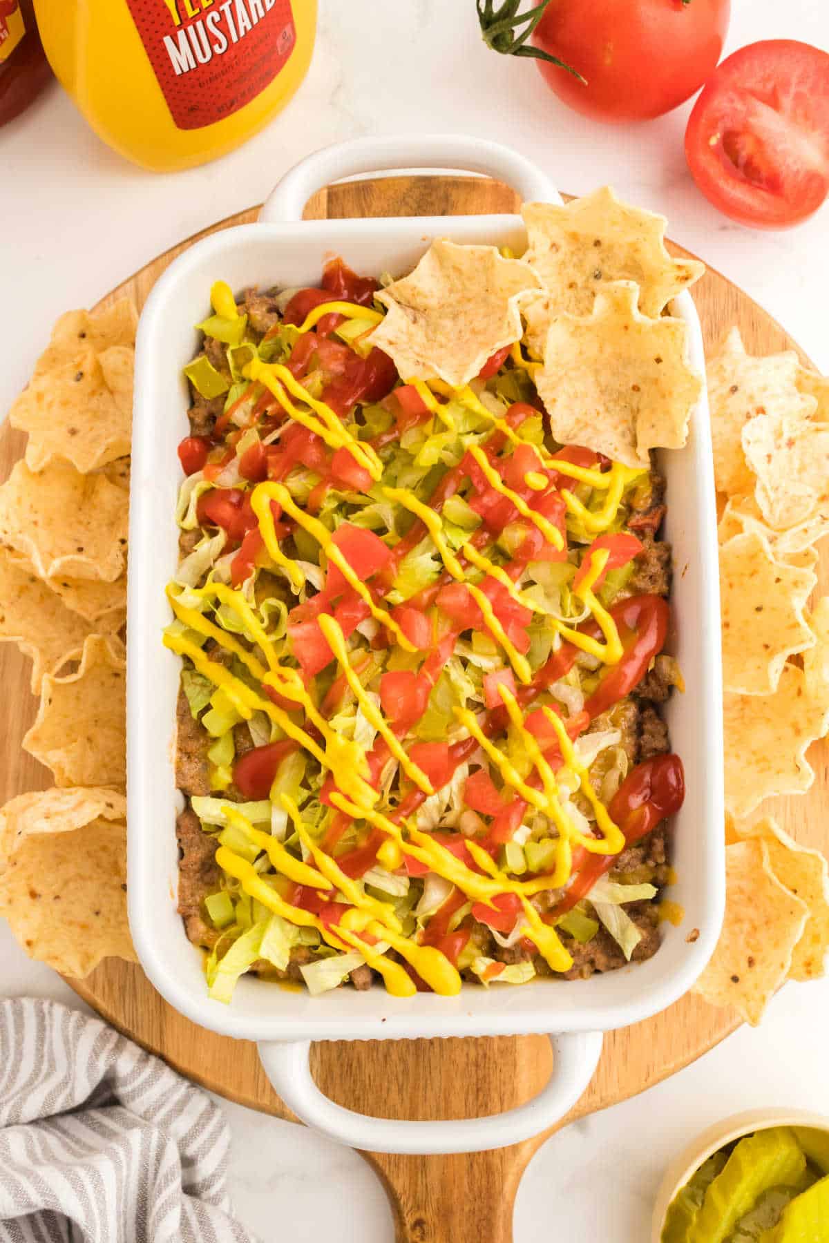 A baking dish with cheeseburger dip surrounded by tortilla chips.