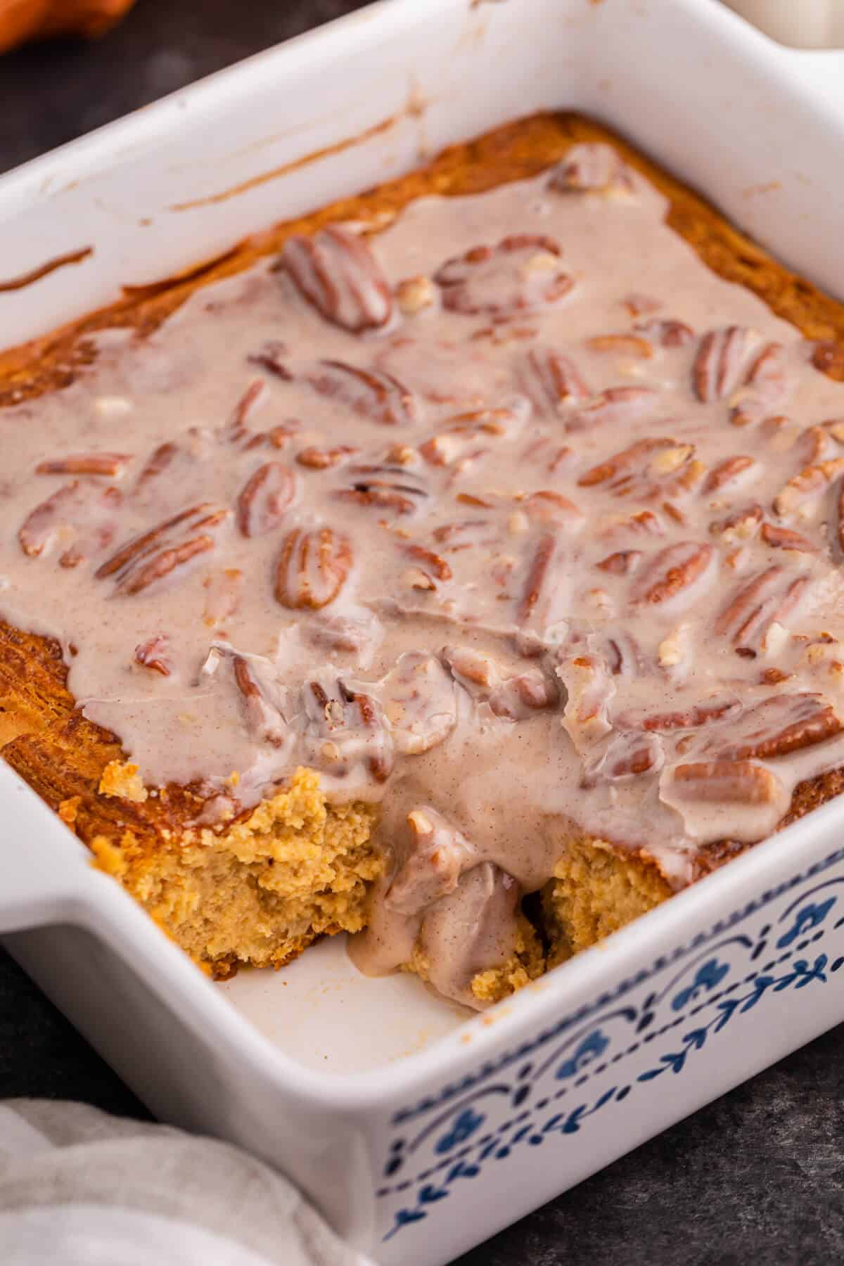 A pan of pumpkin danish bake with a piece missing.