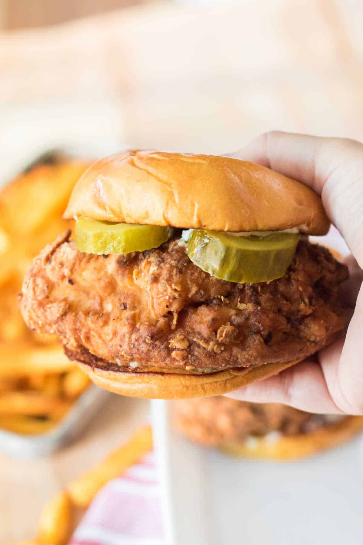 A hand holding a Copycat Popeye's Chicken Sandwich.