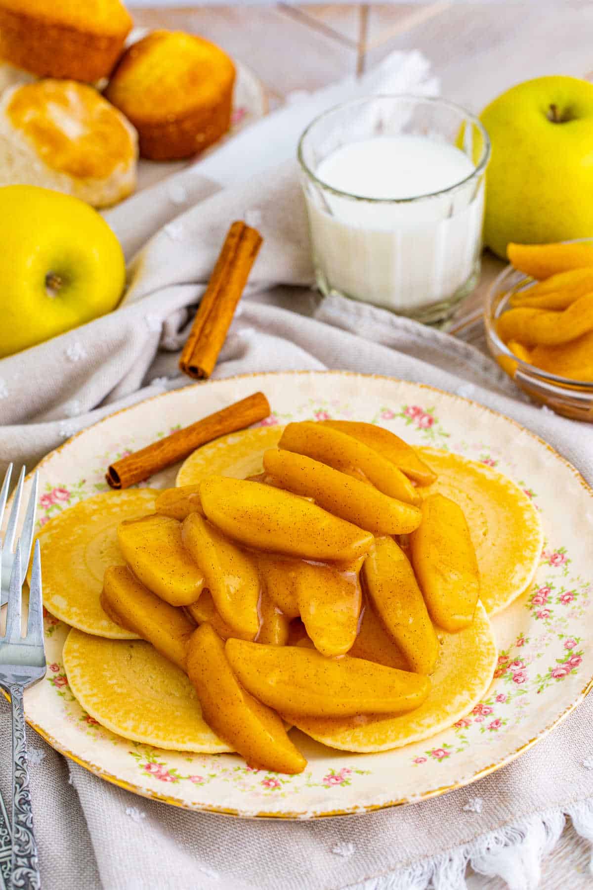 Fried apples served on pancakes on a plate.