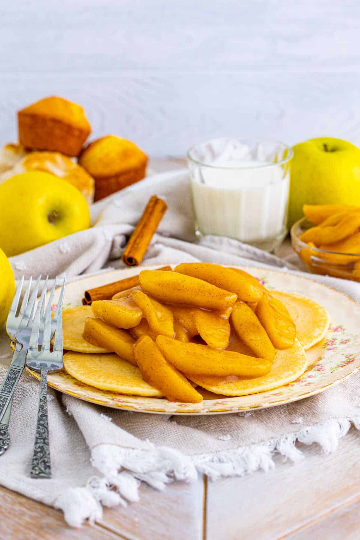 Fried apples on pancakes on a plate.
