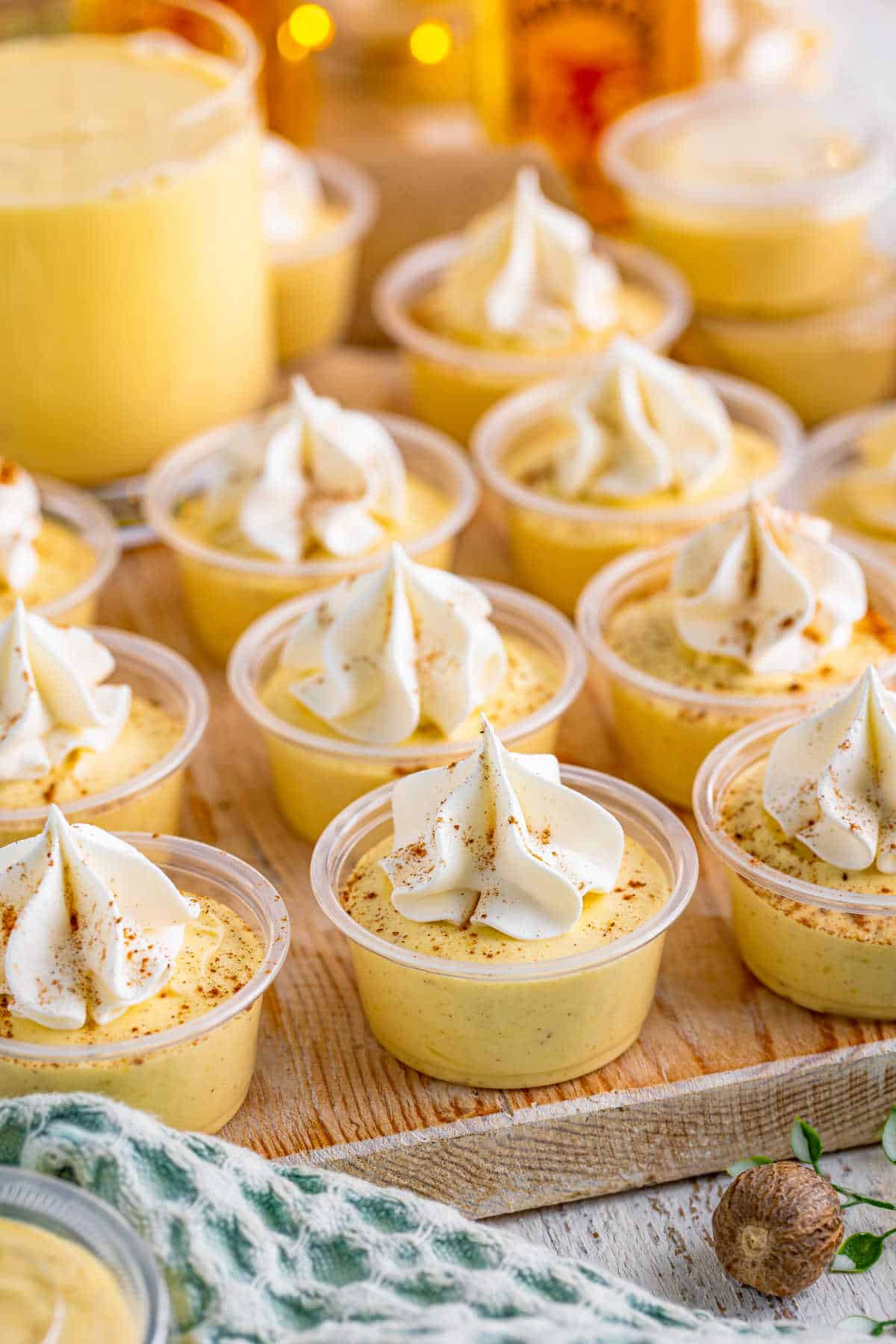 A wooden tray of eggnog pudding shots.