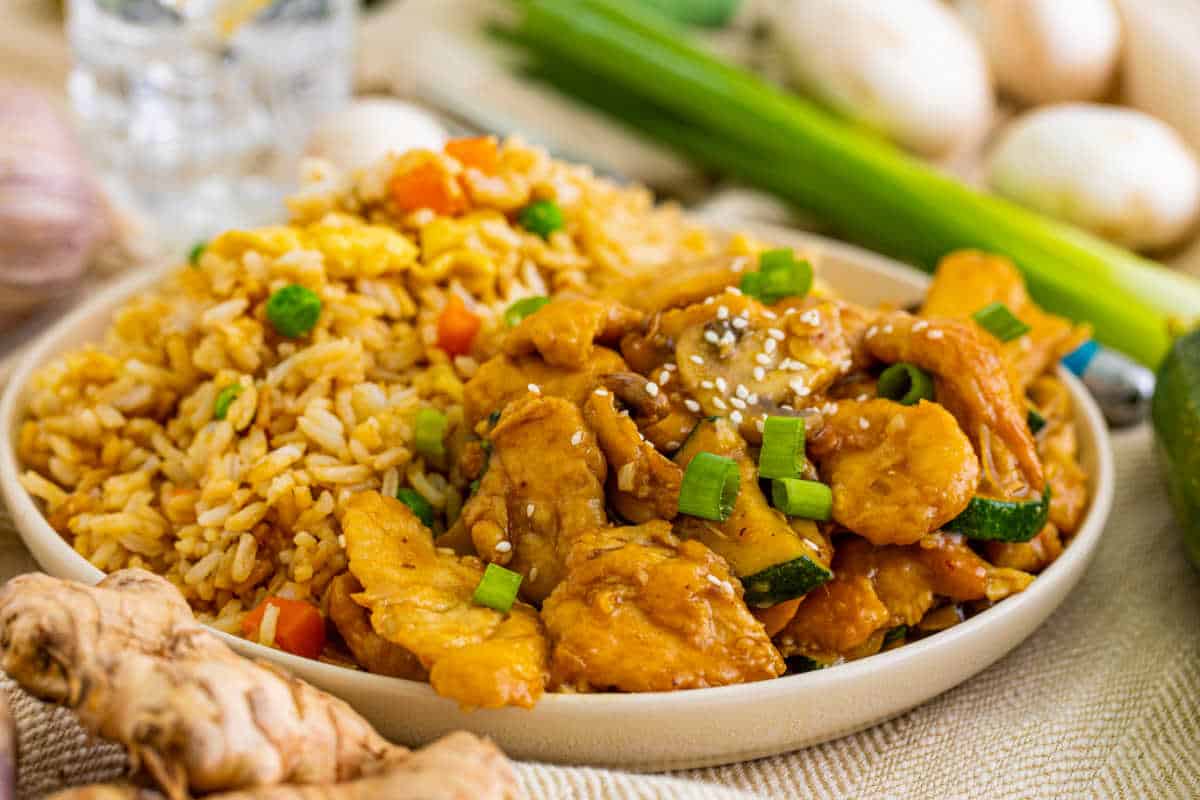 A plate of Panda Express Mushroom Chicken with fried rice.