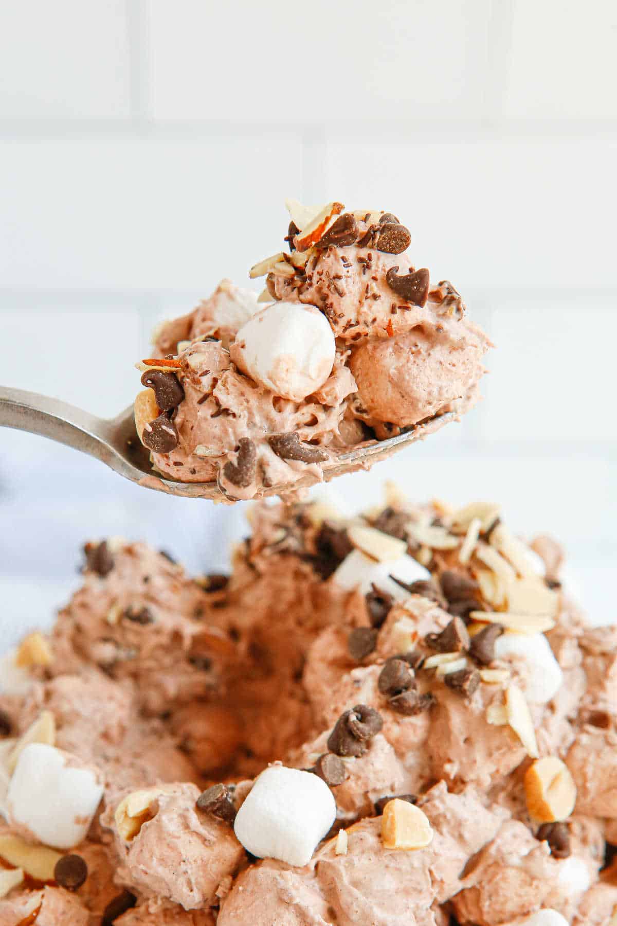 A spoon with rocky road fluff on it.