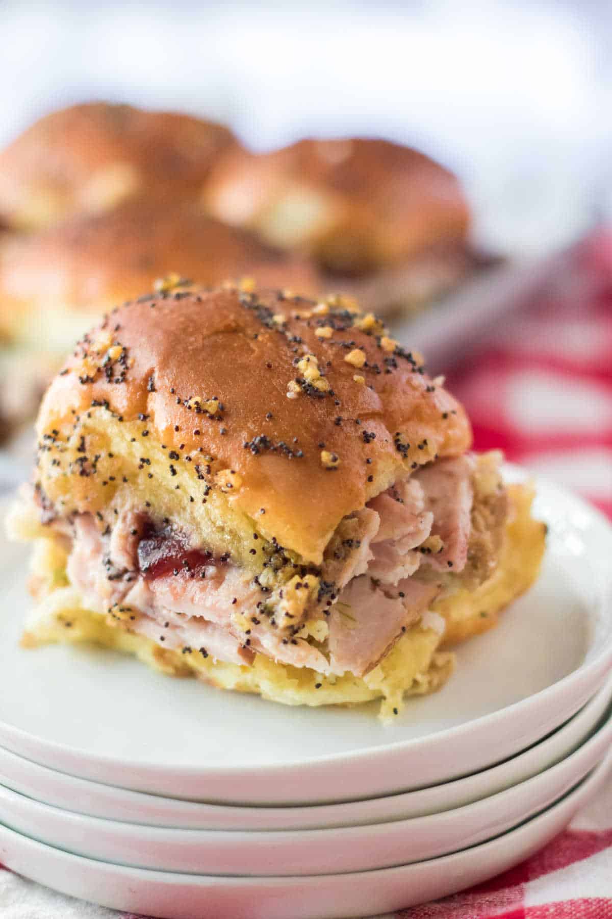 Thanksgiving slider on a stack of white plates.