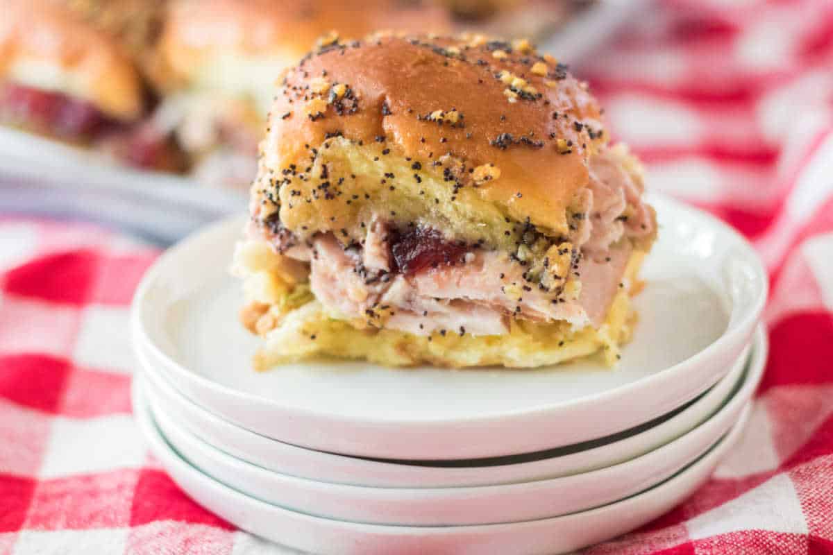 Thanksgiving turkey slider on a stack of white plates.