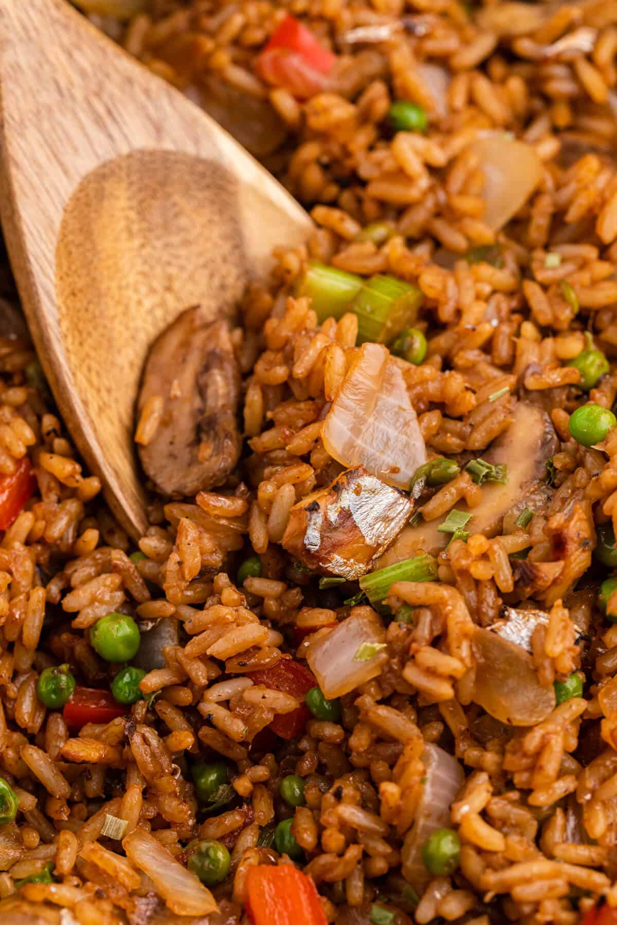 Sardine Fried Rice in a skillet with a wooden spoon.