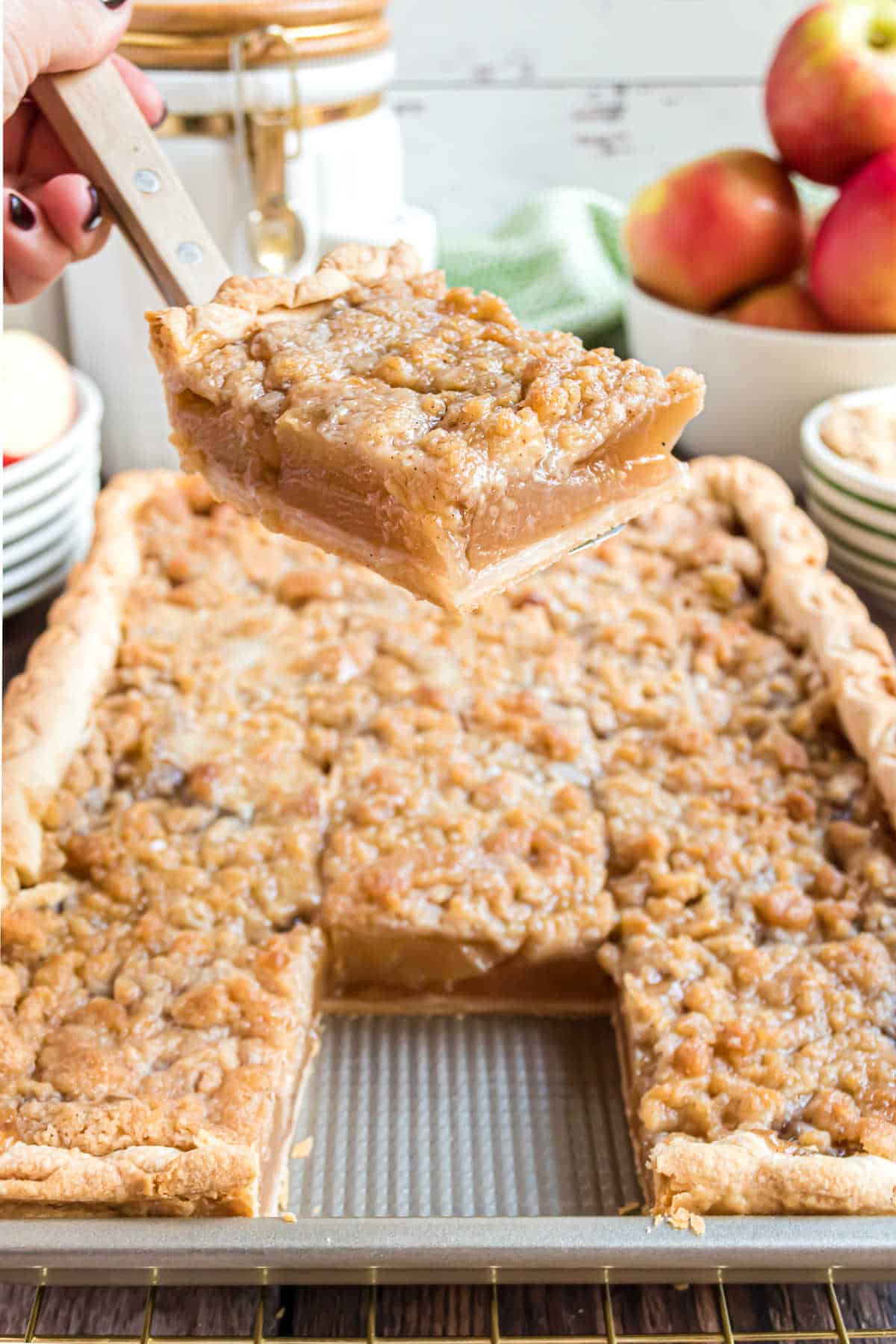 A serving spatula with a square slice of apple slab pie.