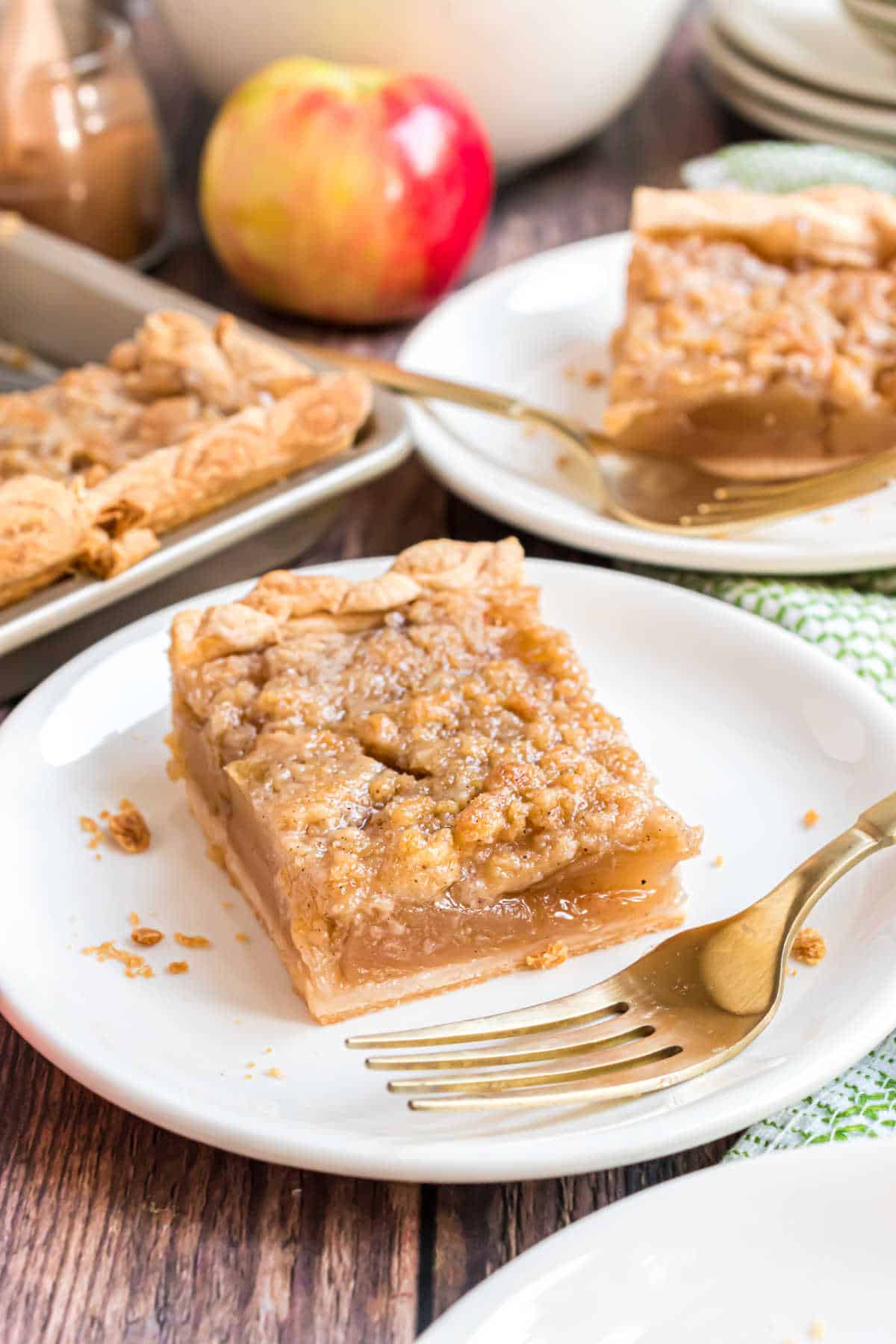 A slice of apple slab pie on a plate with a fork.
