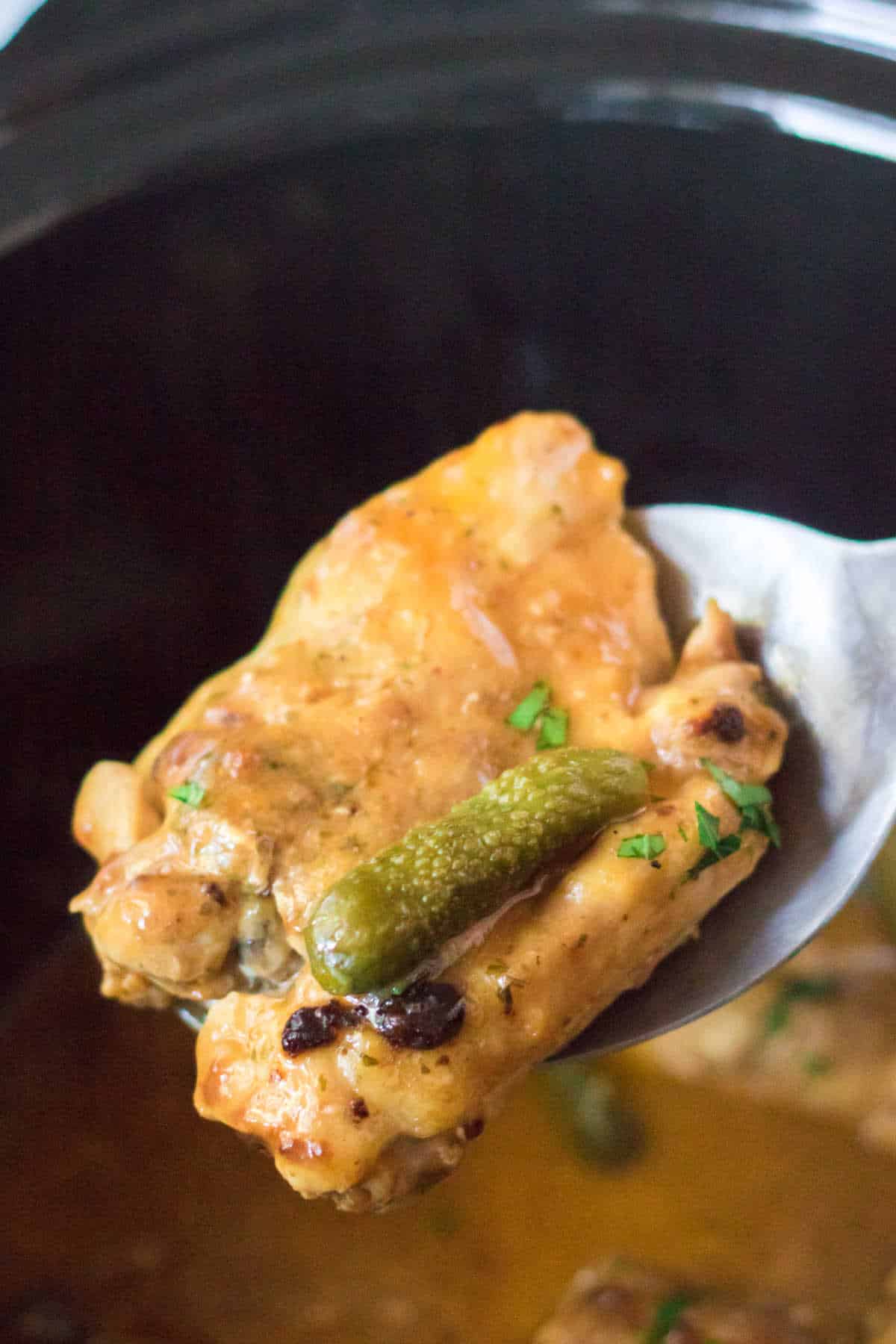 Pickle chicken on a serving spoon.