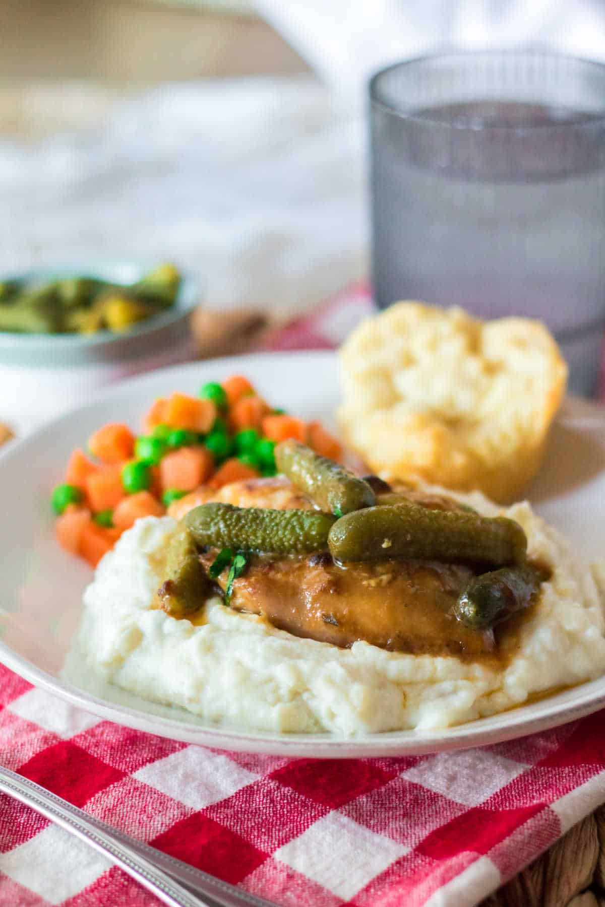 Pickle chicken on mashed potatoes on a plate.