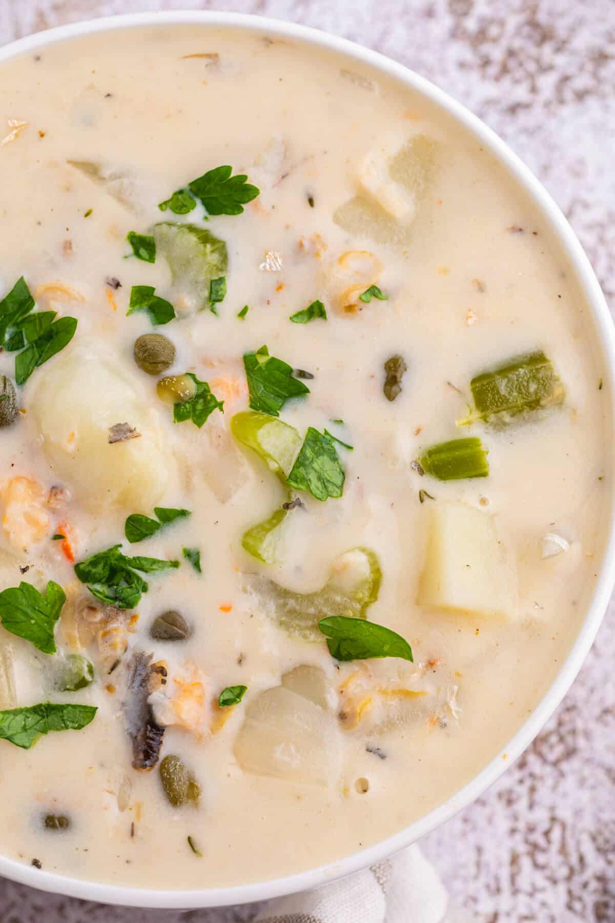 A white bowl of seafood chowder.