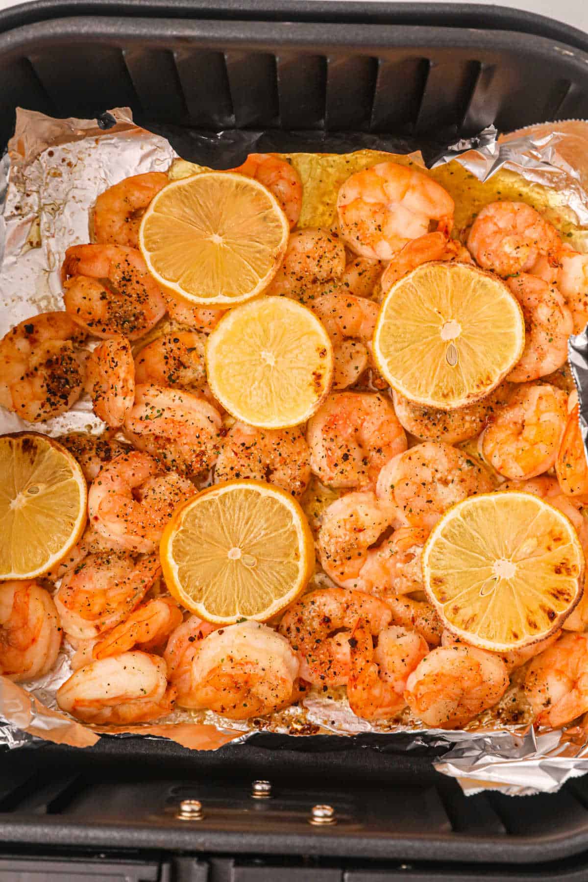 Shrimp in an air fryer basket.