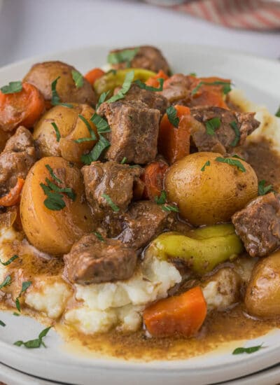 A plate of mashed potatoes with beef stew.