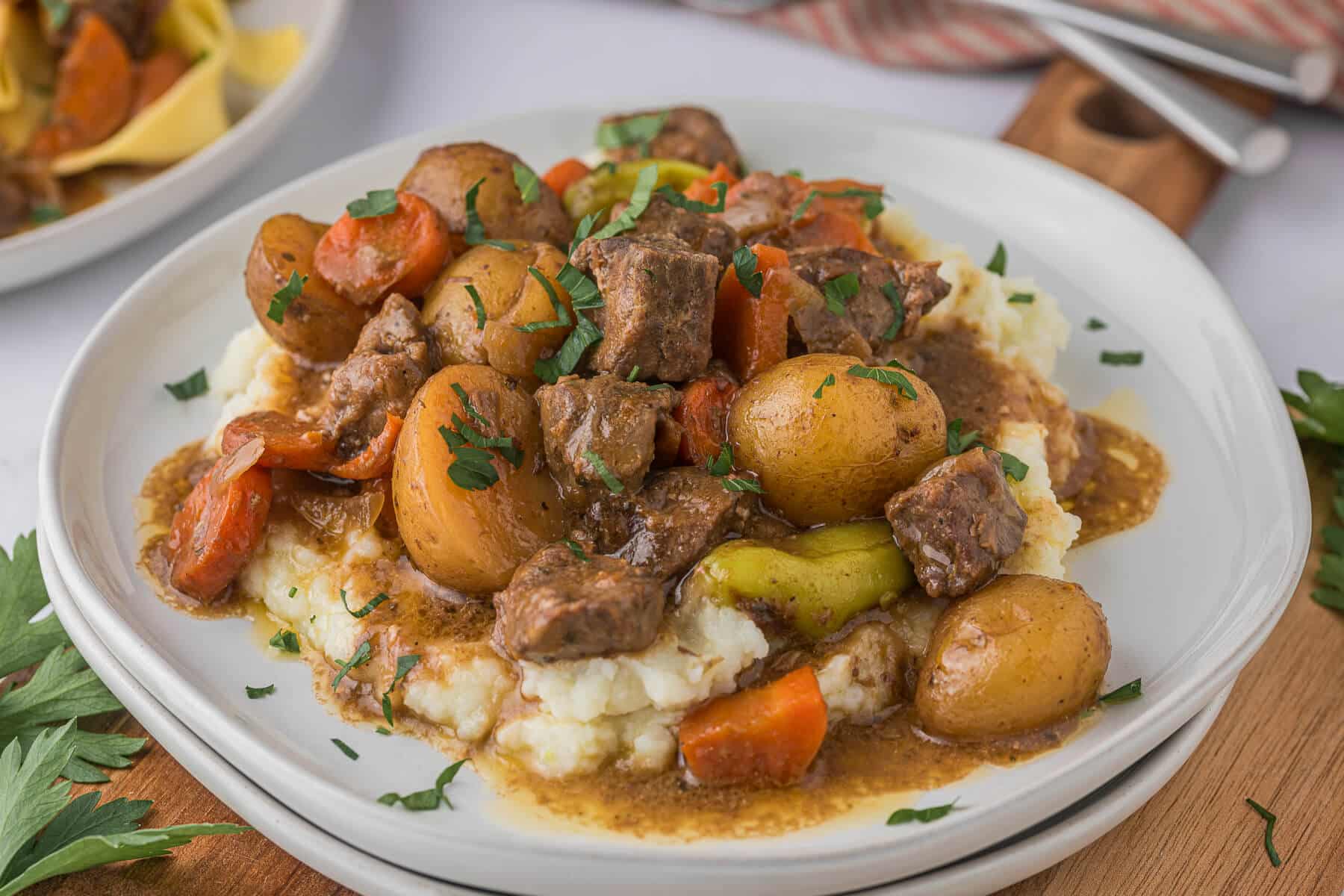 A plate of mashed potatoes with beef stew.