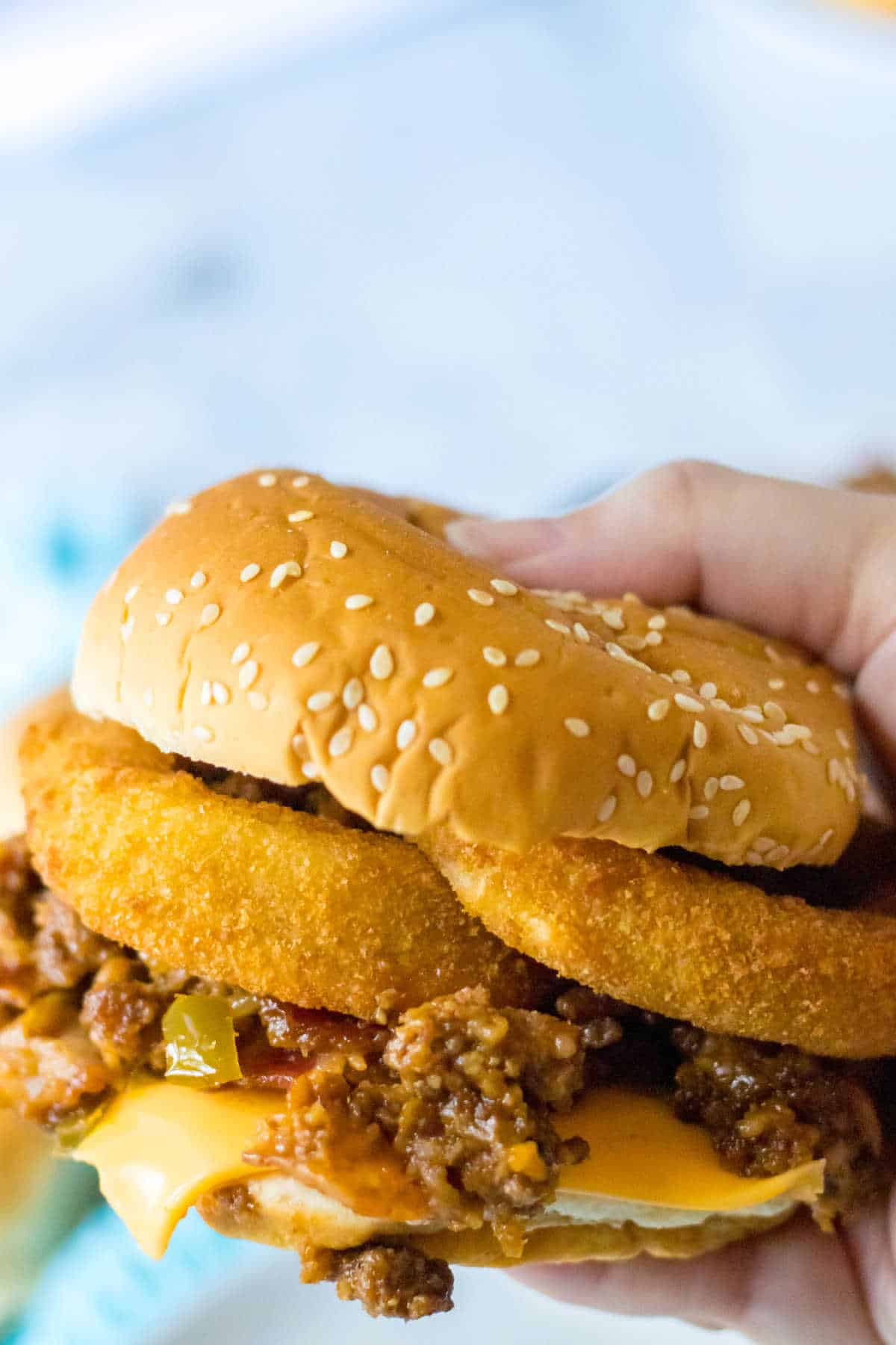 A hand holding a rodeo sloppy joe.