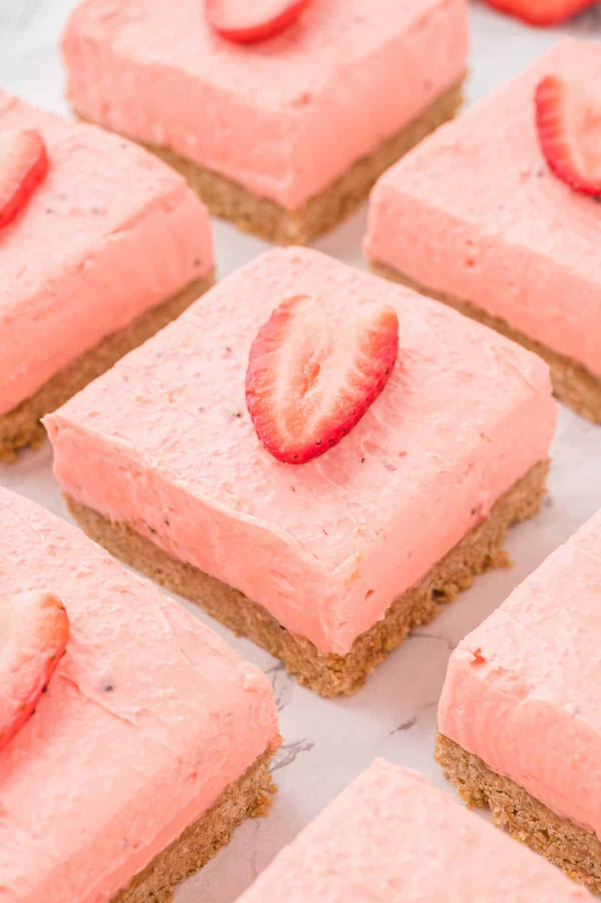 Strawberry cheesecake bars cut into squares.