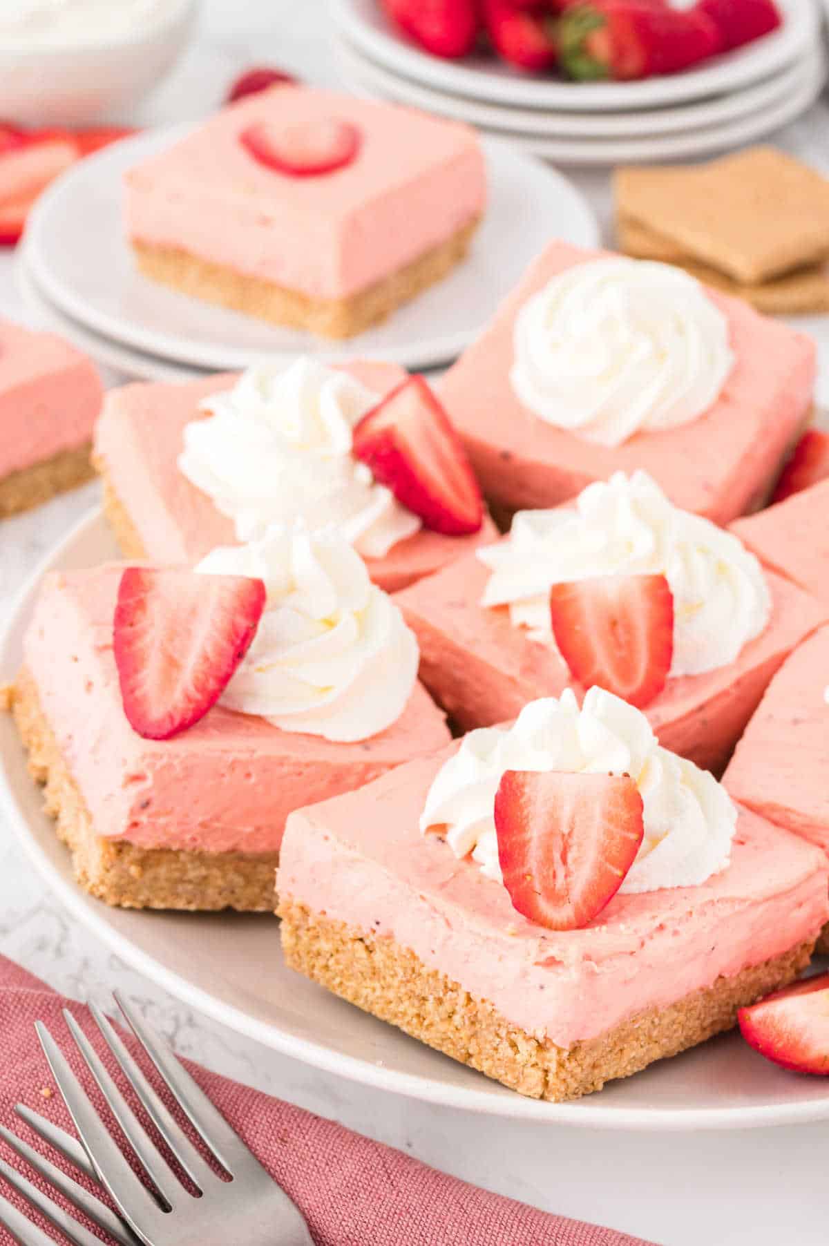 A plate of strawberry cheesecake bars.