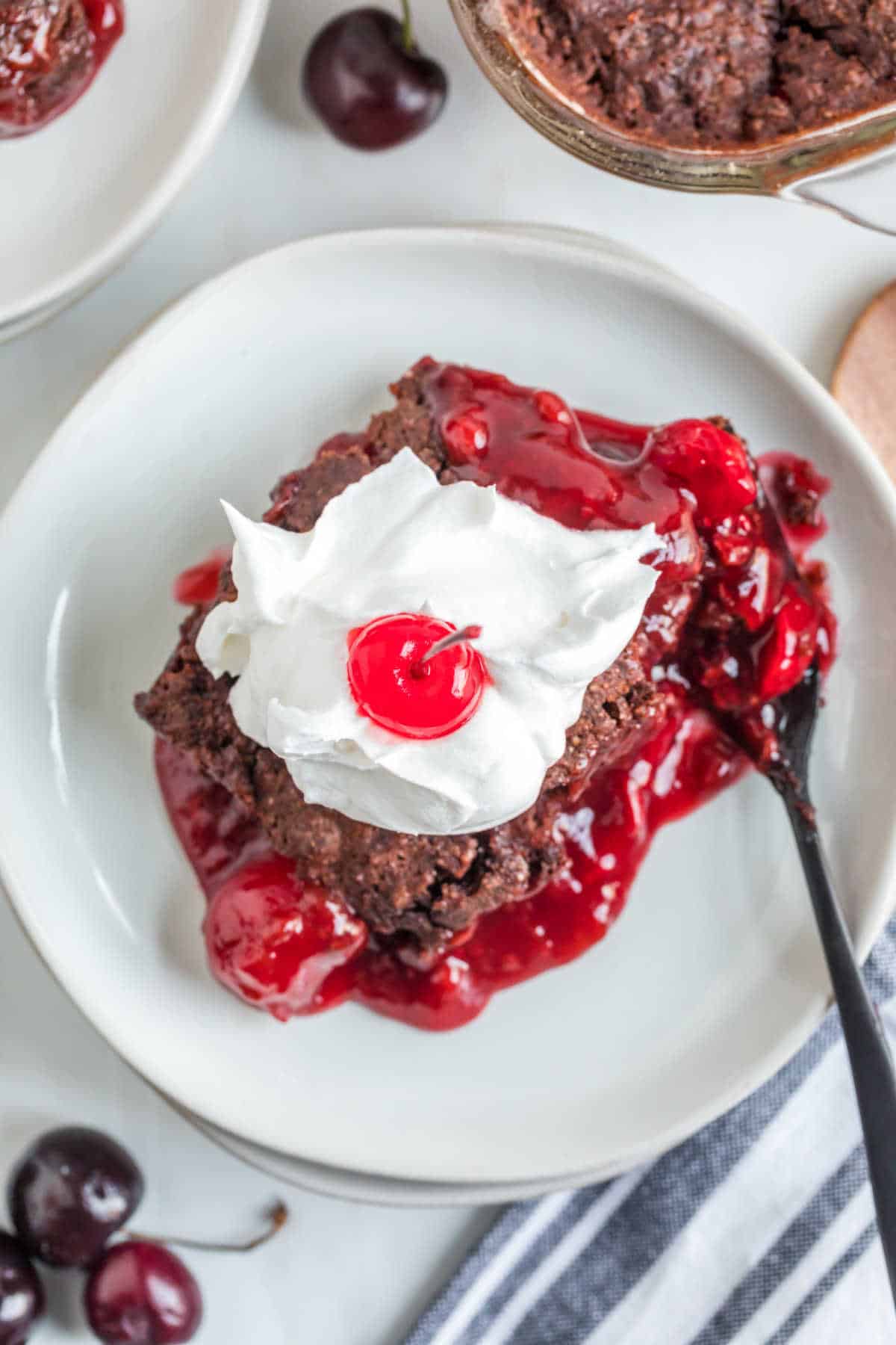 A slice of black forest dump cake on a plate.