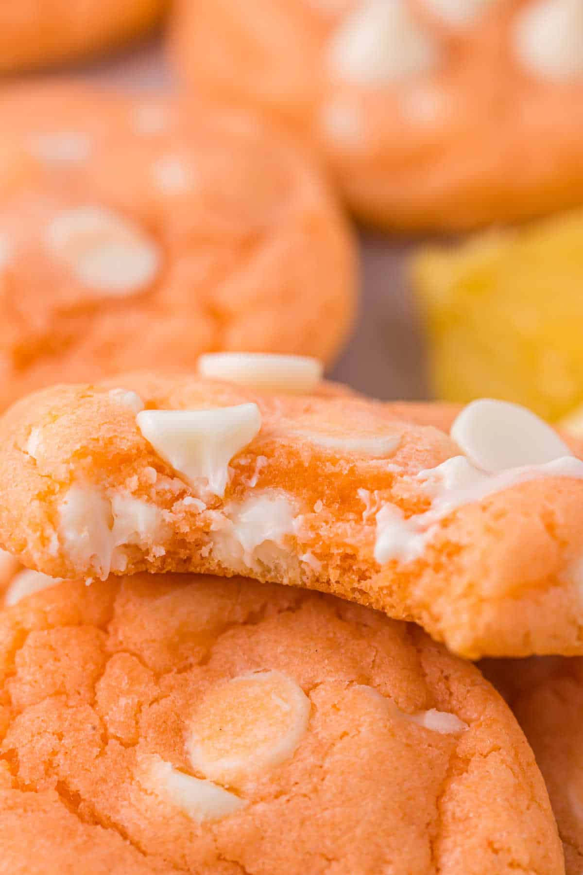 An orange creamsicle cookie with a bite out of it.