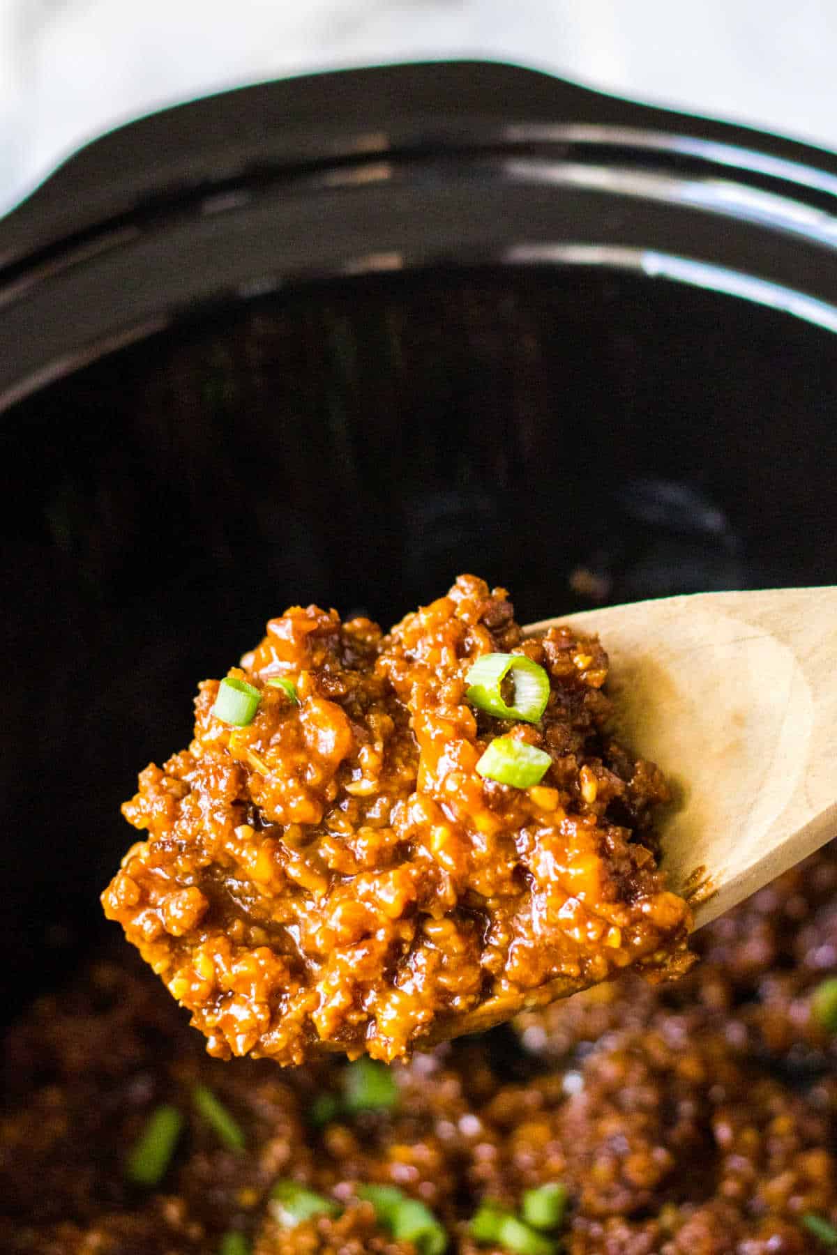 Korean sloppy joe meat on a wooden serving spoon.