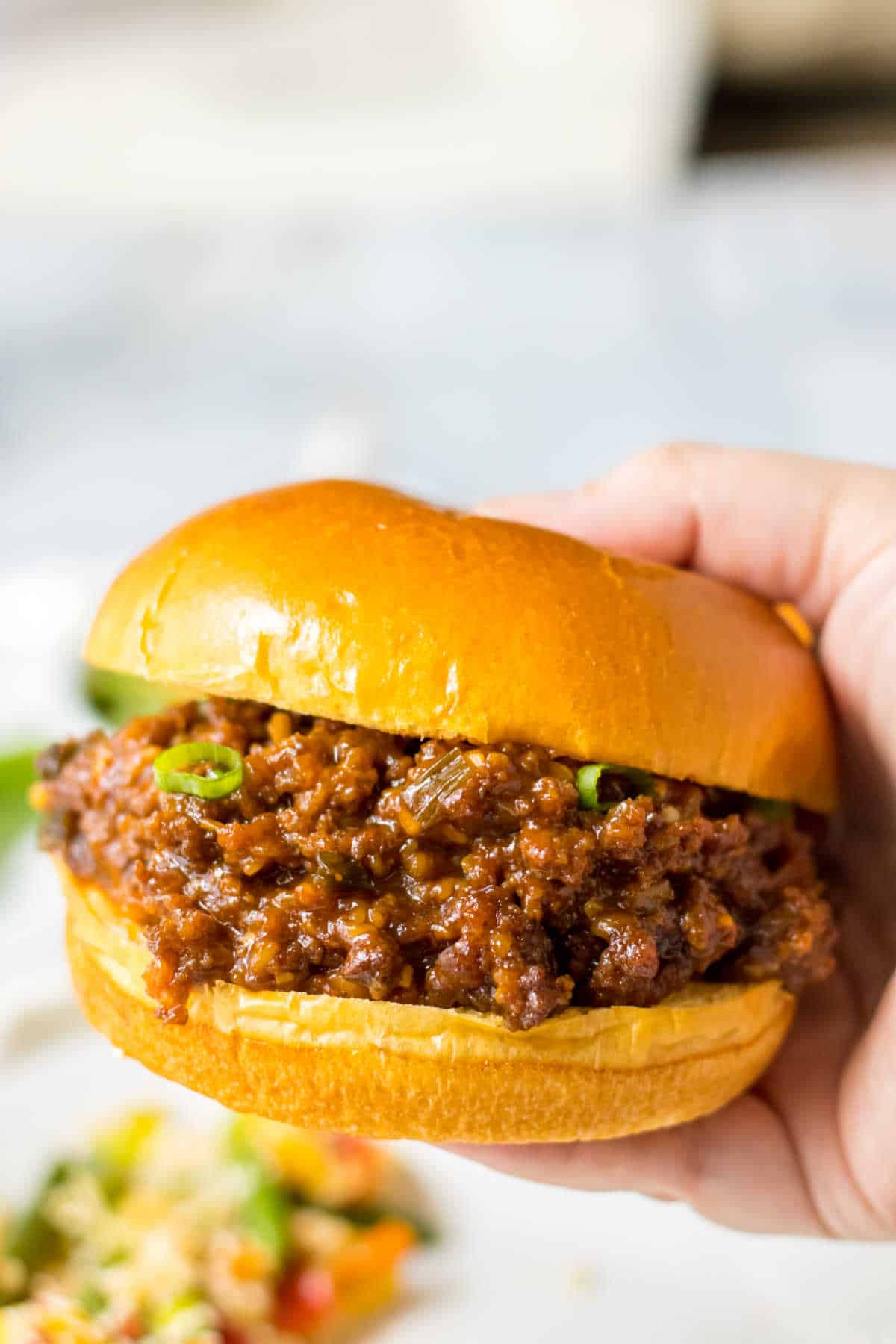 A hand holding a Korean sloppy joe.