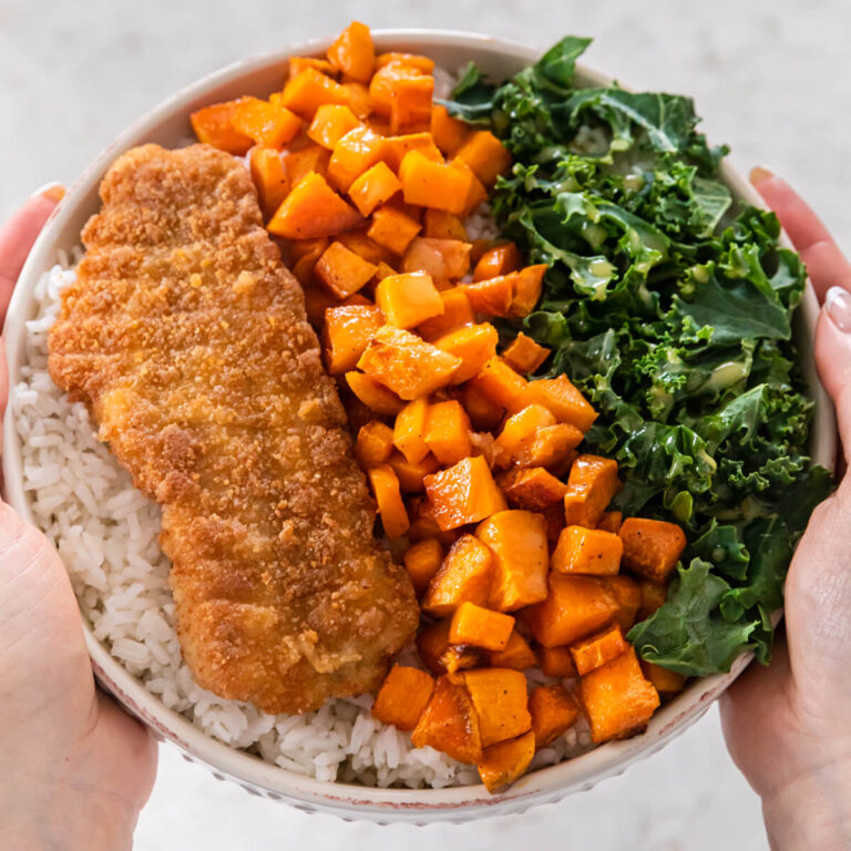 Hands holding a haddock buddha bowl.