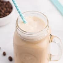 Iced coffee in a jar with a straw.