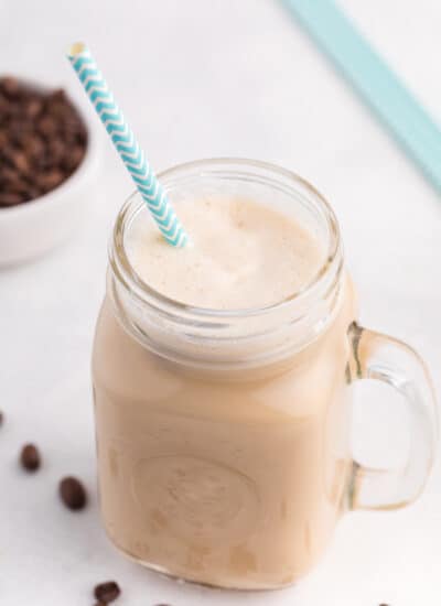 Iced coffee in a jar with a straw.