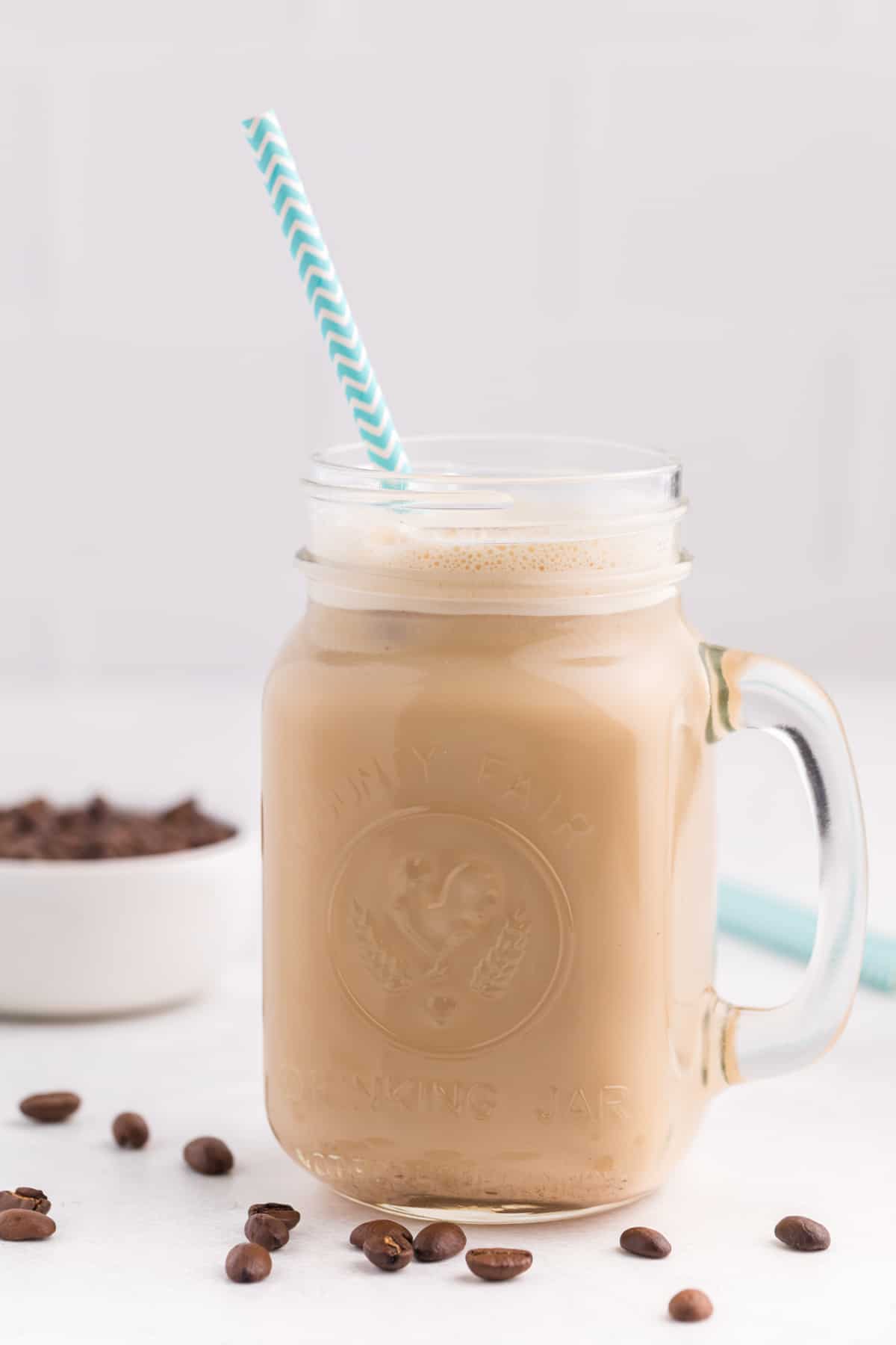 An iced coffee in a jar with a straw.