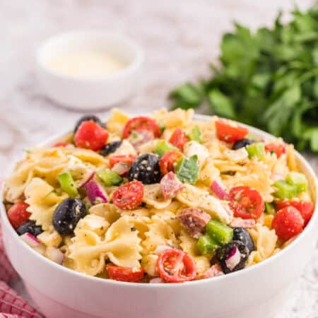 The salad in a white bowl with ingredients in the background.
