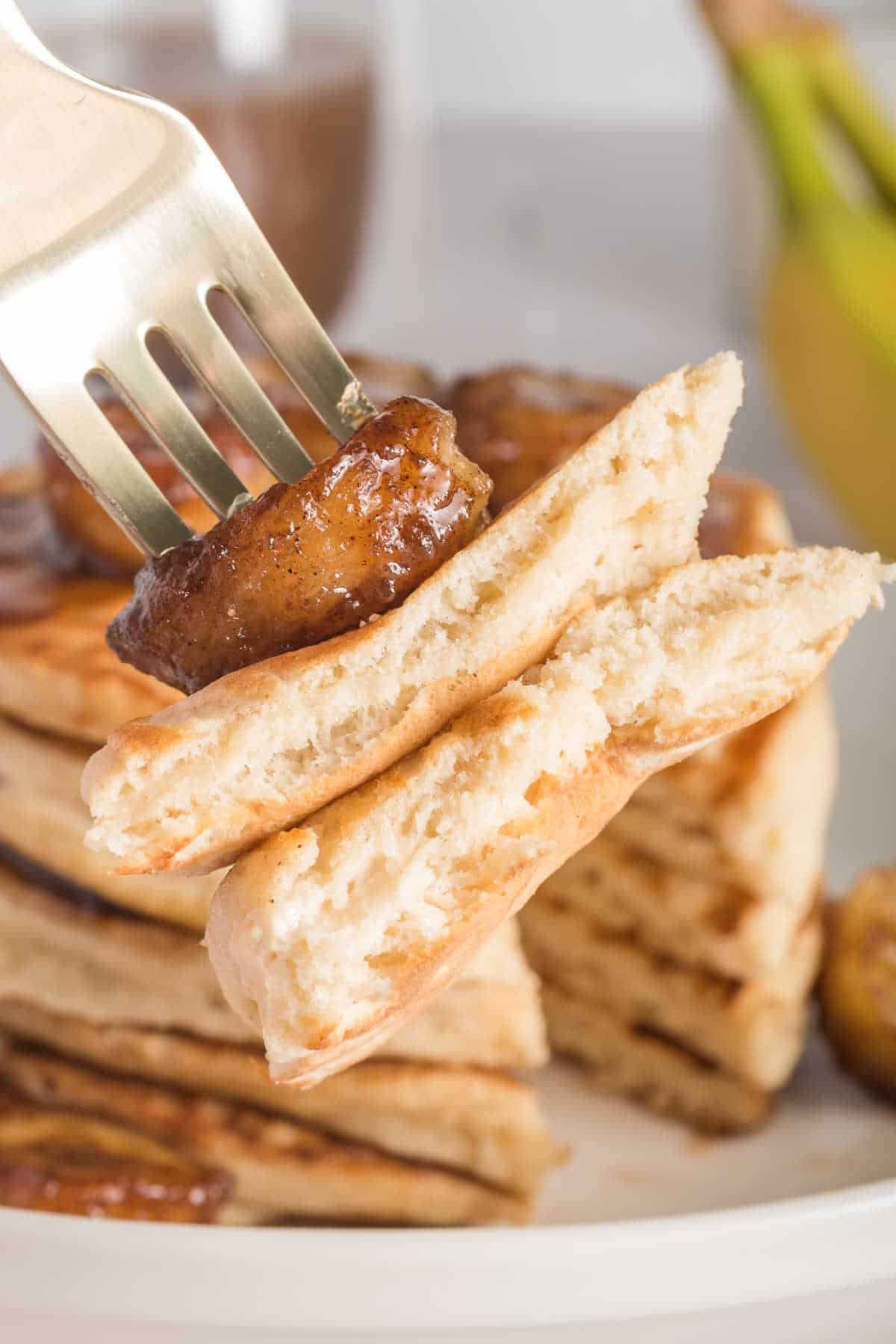 A fork with bananas foster pancakes.