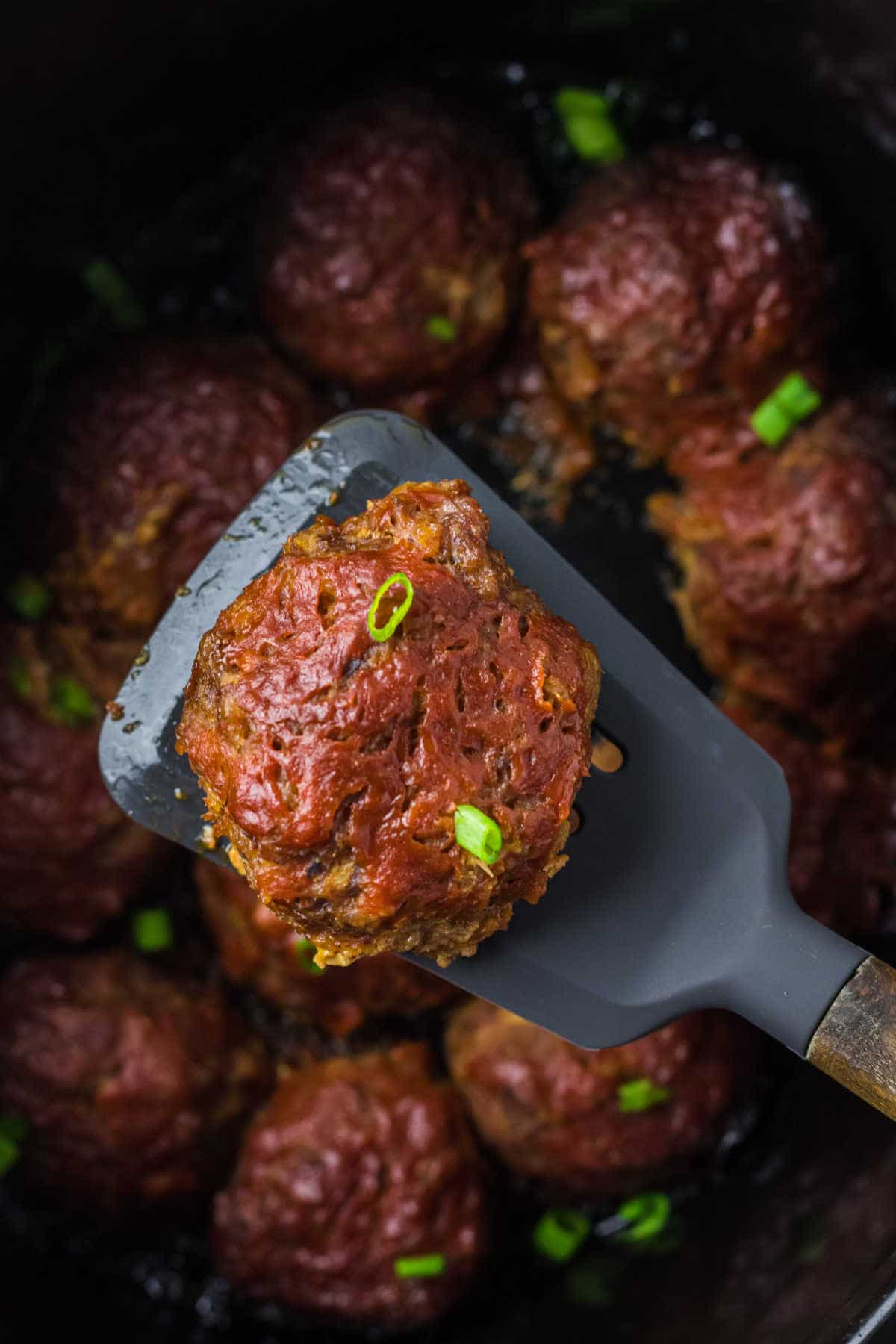 A pineapple ham ball on a spatula.