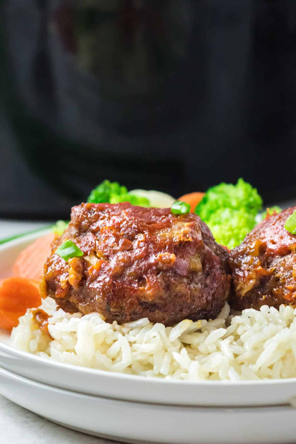 Pineapple ham balls on a bed of white rice on a plate.