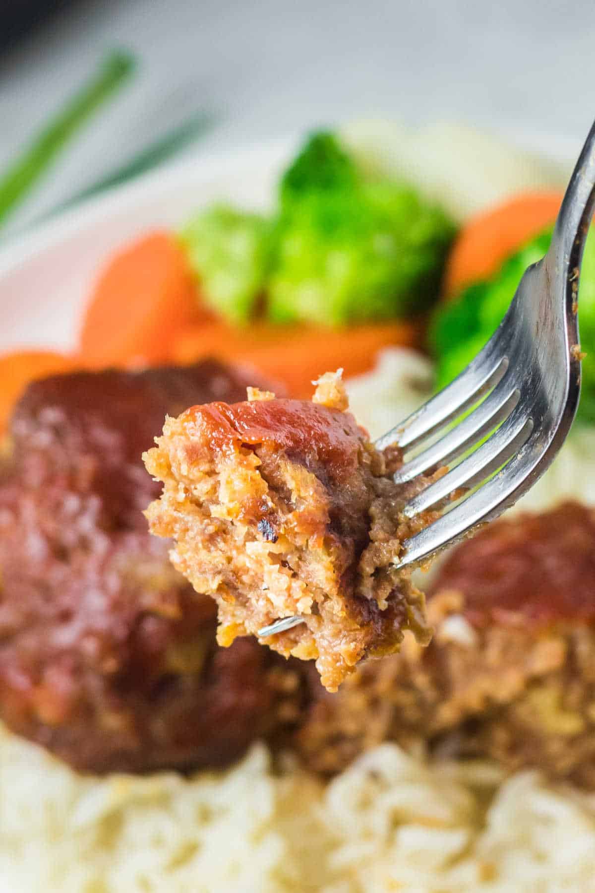 A piece of pineapple ham ball on a fork.