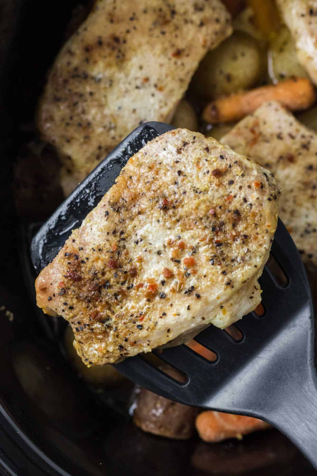 A pork chop on a spatula.