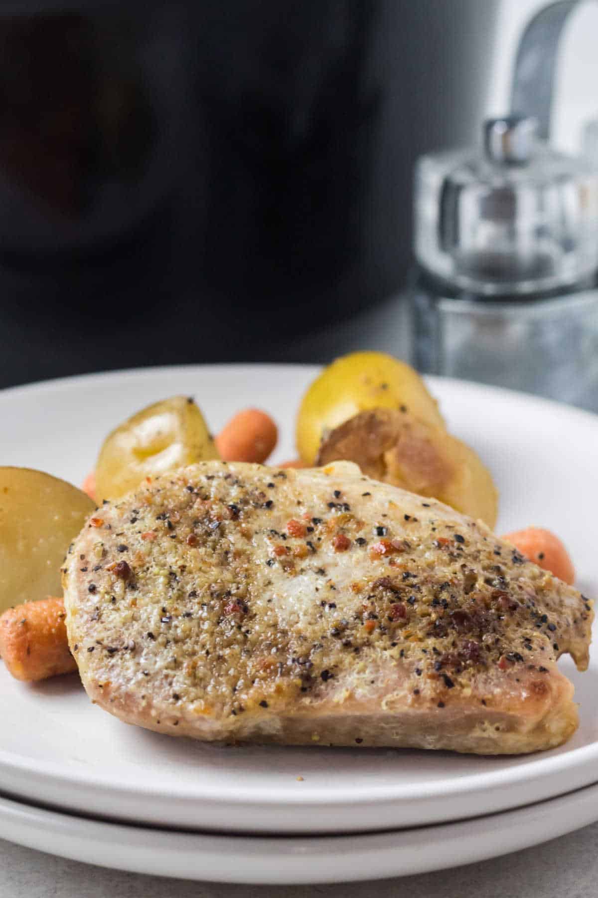 An Italian pork chop on a plate with veggies.