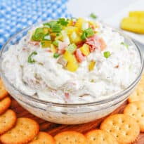 Dill pickle dip in a bowl with crackers around.